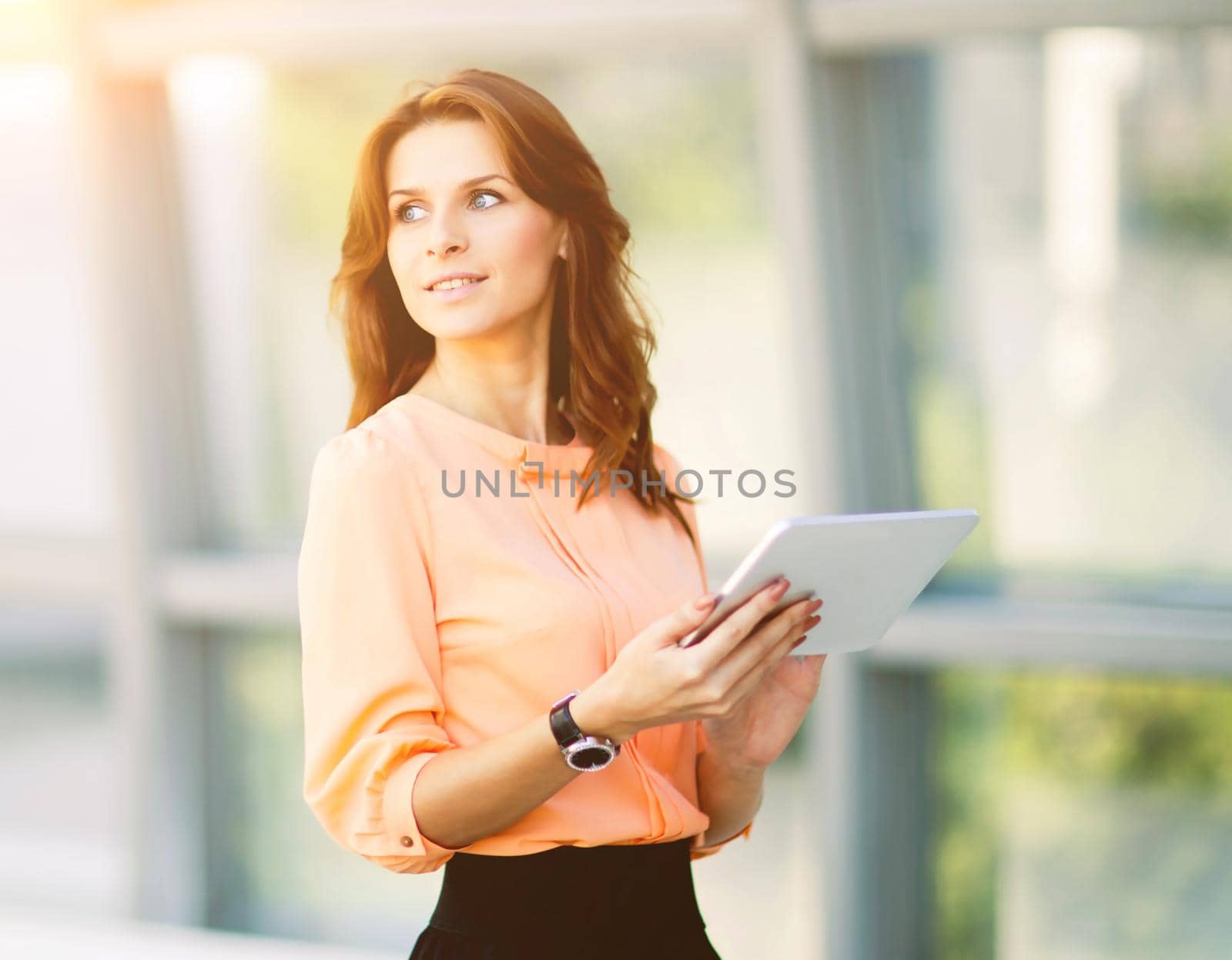 Successful business woman holding a digital tablet computer in the office, there is an empty space for text