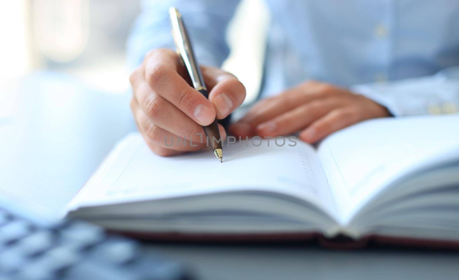 Businesswoman makes a note in notebook.