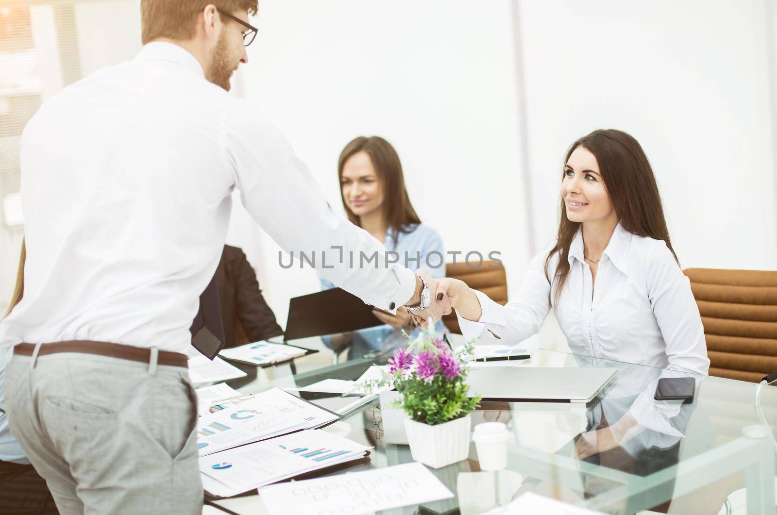 handshake with a senior Manager and a client at a business meeting in a modern office