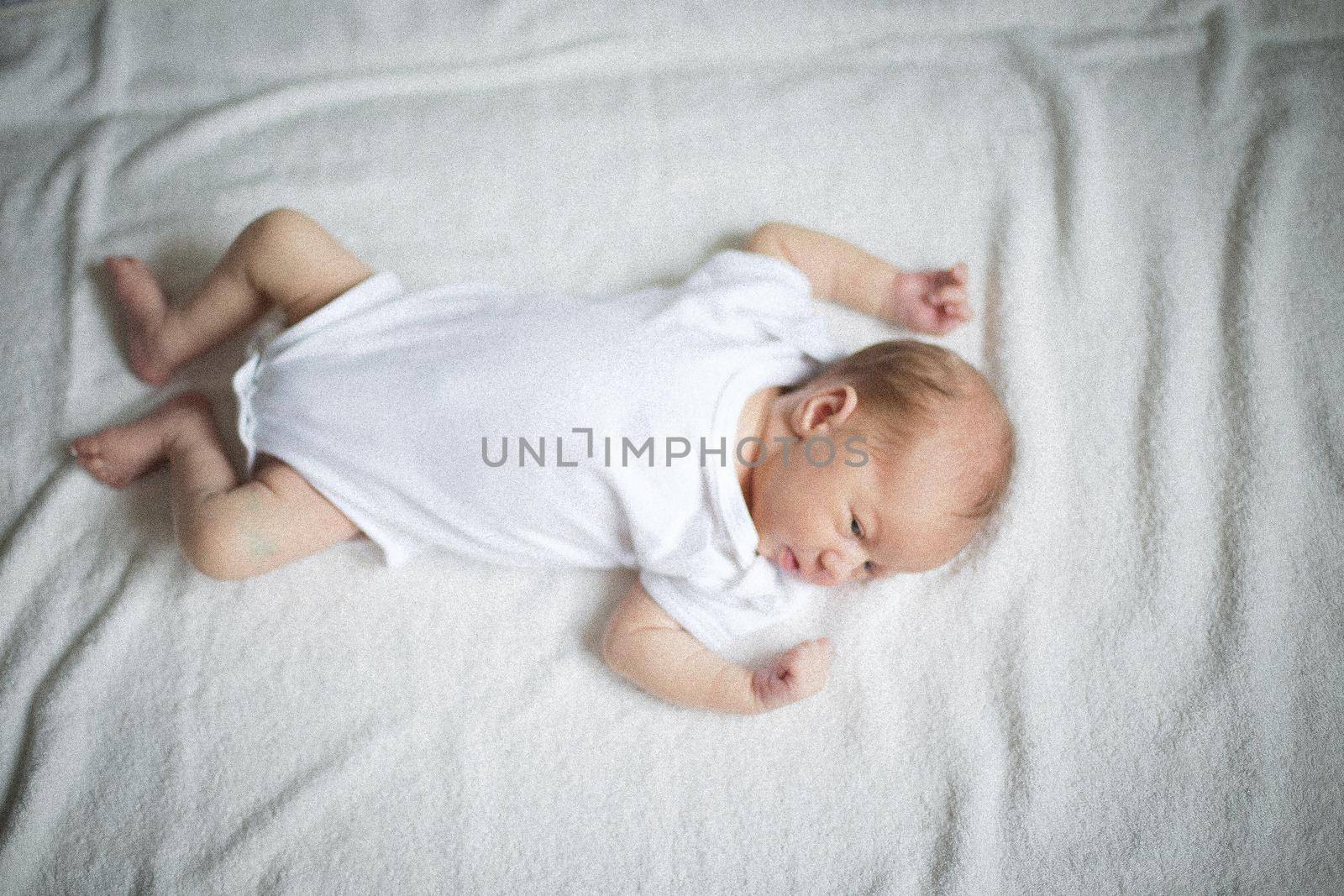cute newborn baby sleeping on the bed .the photo has a empty space for your text