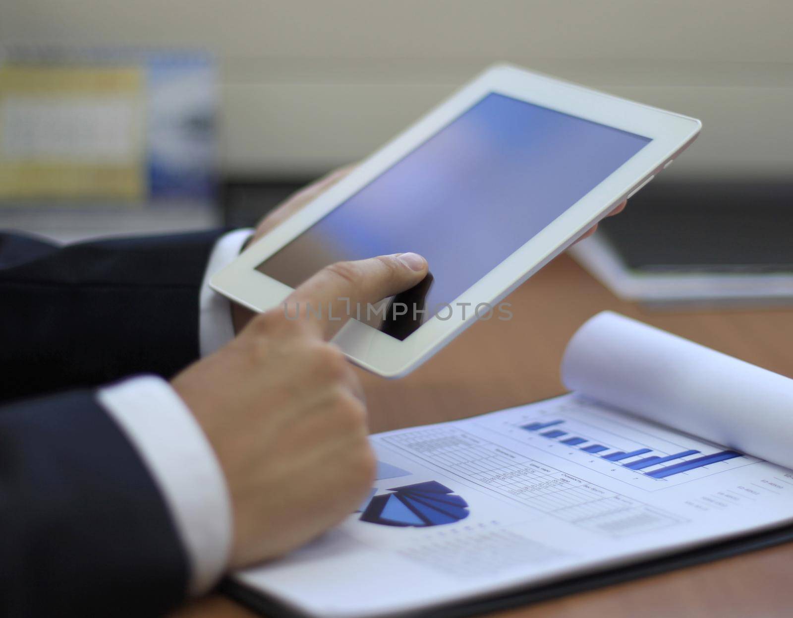 Image of human hand pointing at touchscreen in working environment at meeting