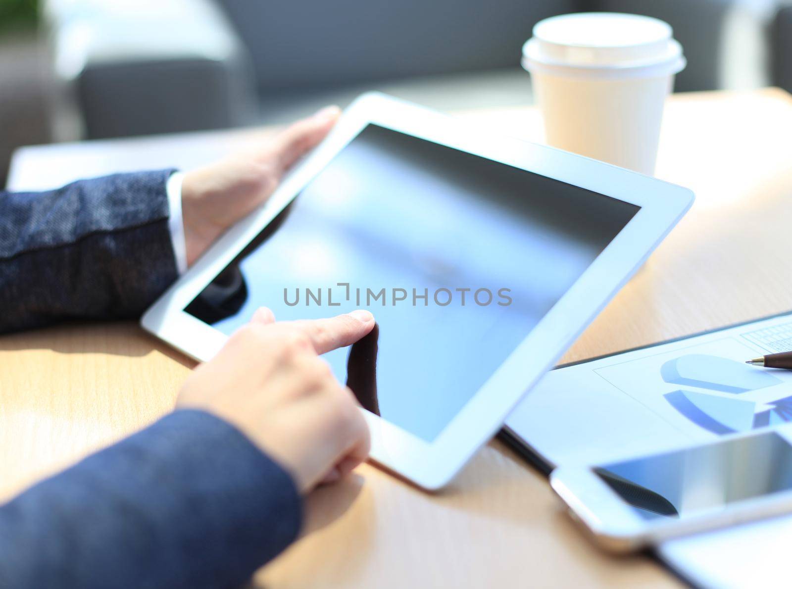 Woman hand touching screen on modern digital tablet pc. Close-up image with shallow depth of field focus on finger. by tsyhun