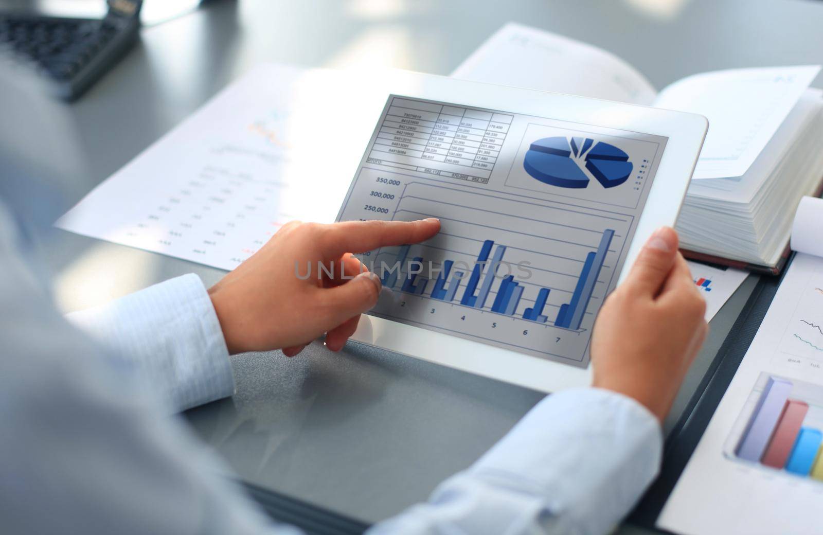 Image of human hand pointing at touchscreen in working environment at meeting by tsyhun