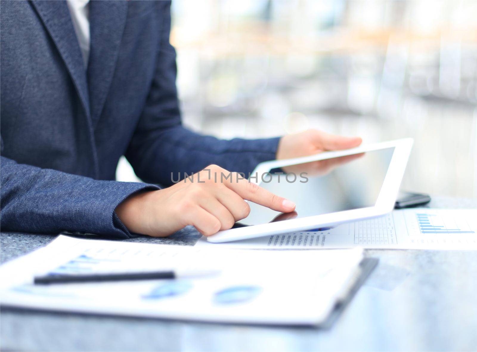 Business person analyzing financial statistics displayed on the tablet screen