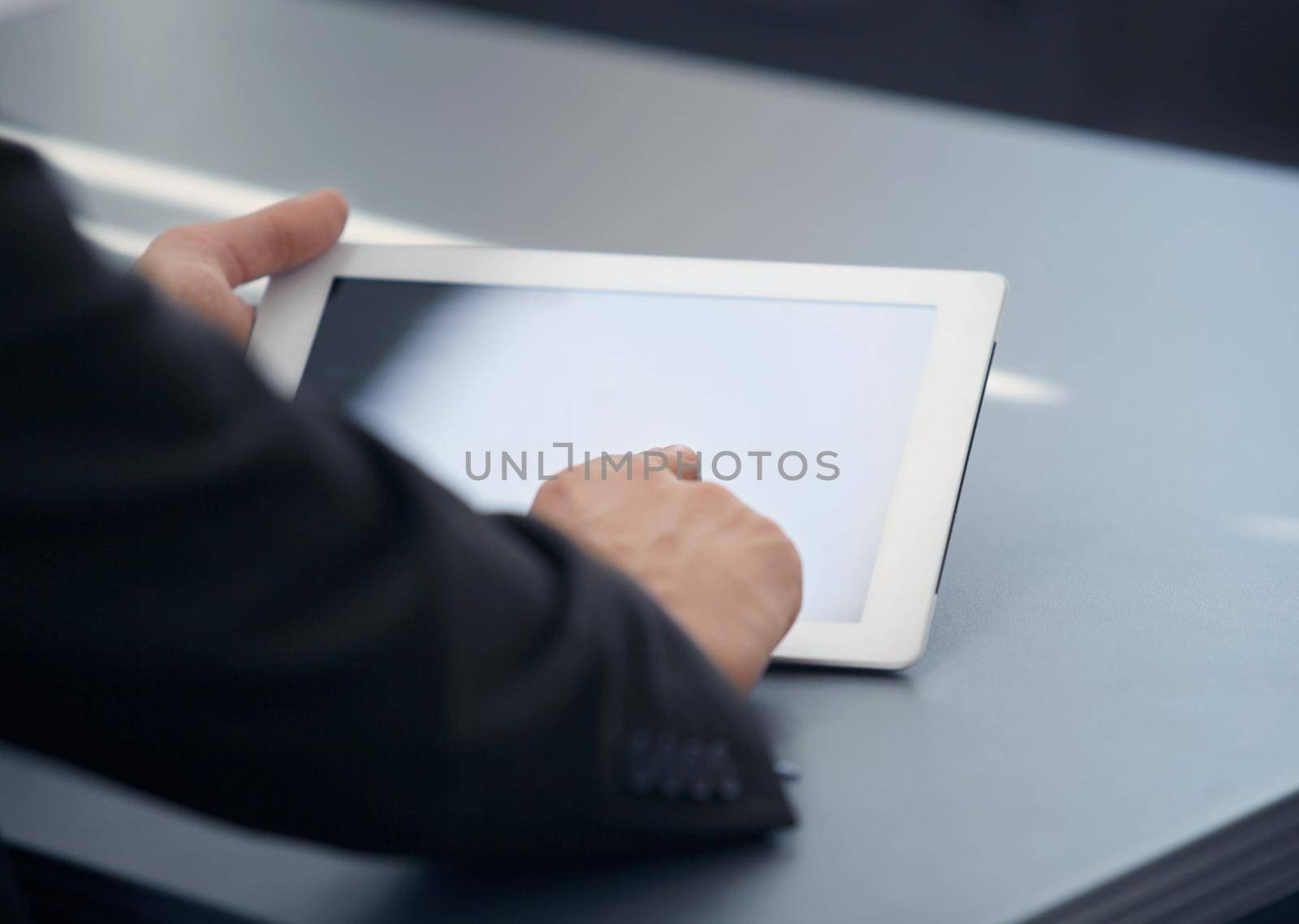 businessman holding digital tablet in office by tsyhun