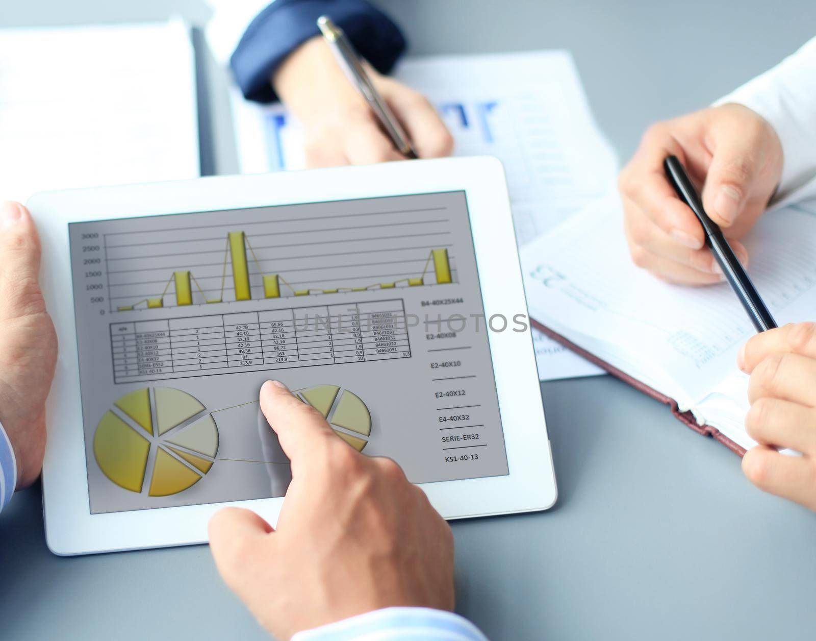 Business person analyzing financial statistics displayed on the tablet screen