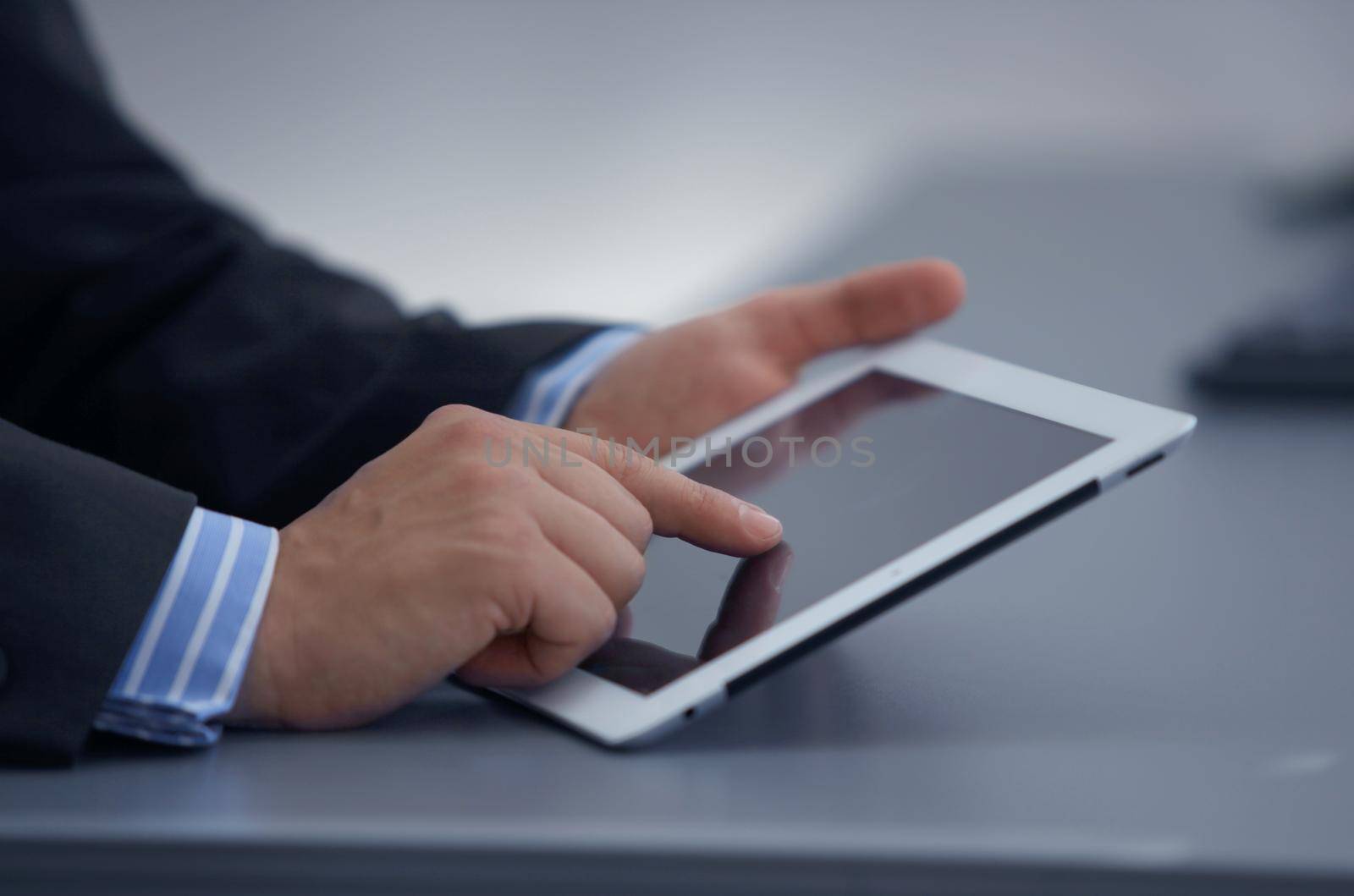 businessman holding digital tablet in office by tsyhun