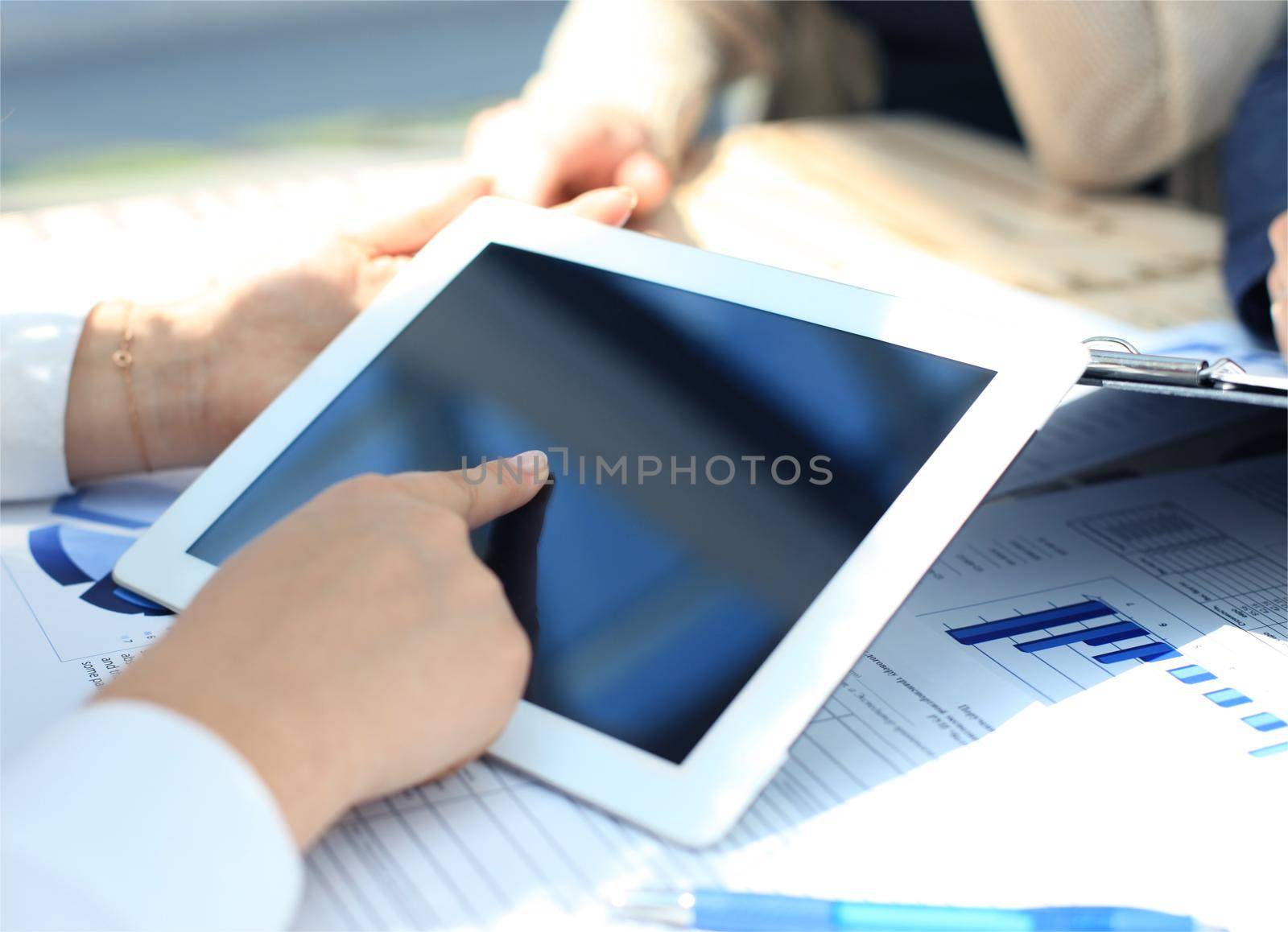 Business person analyzing financial statistics displayed on the tablet screen