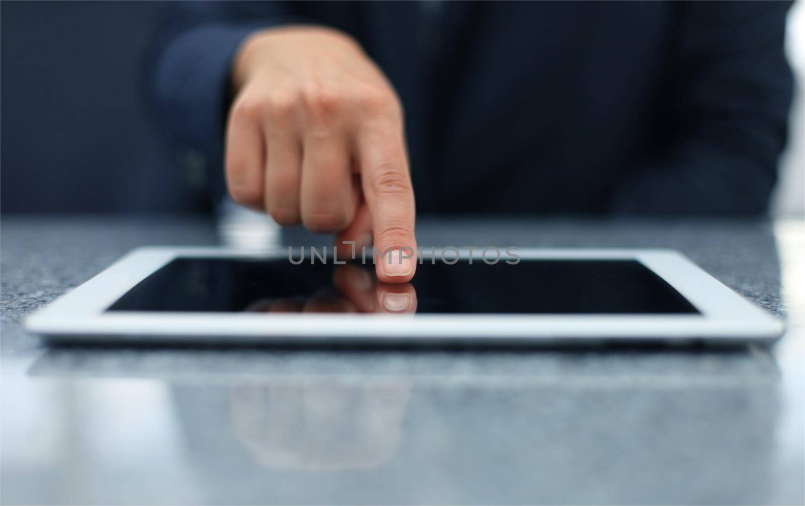Woman hand touching screen on modern digital tablet pc. Close-up image with shallow depth of field focus on finger. by tsyhun