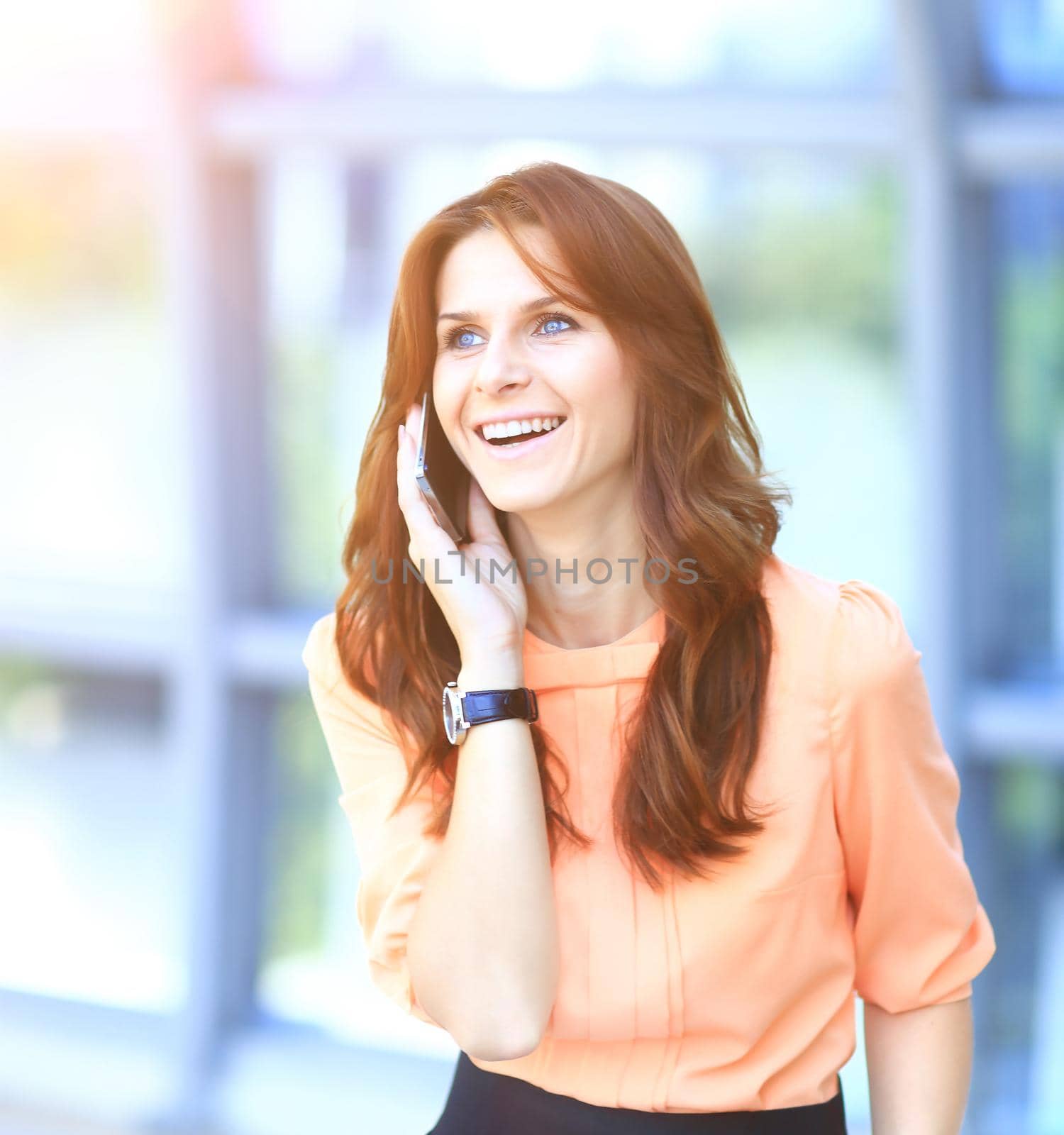 Modern successful business woman in the office talking on the phone