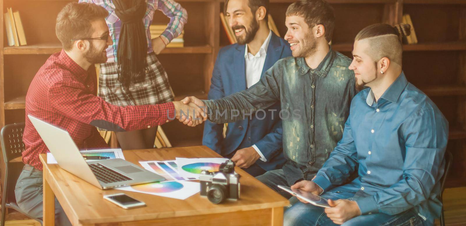 advertising Manager with a handshake greets the customer in a modern office