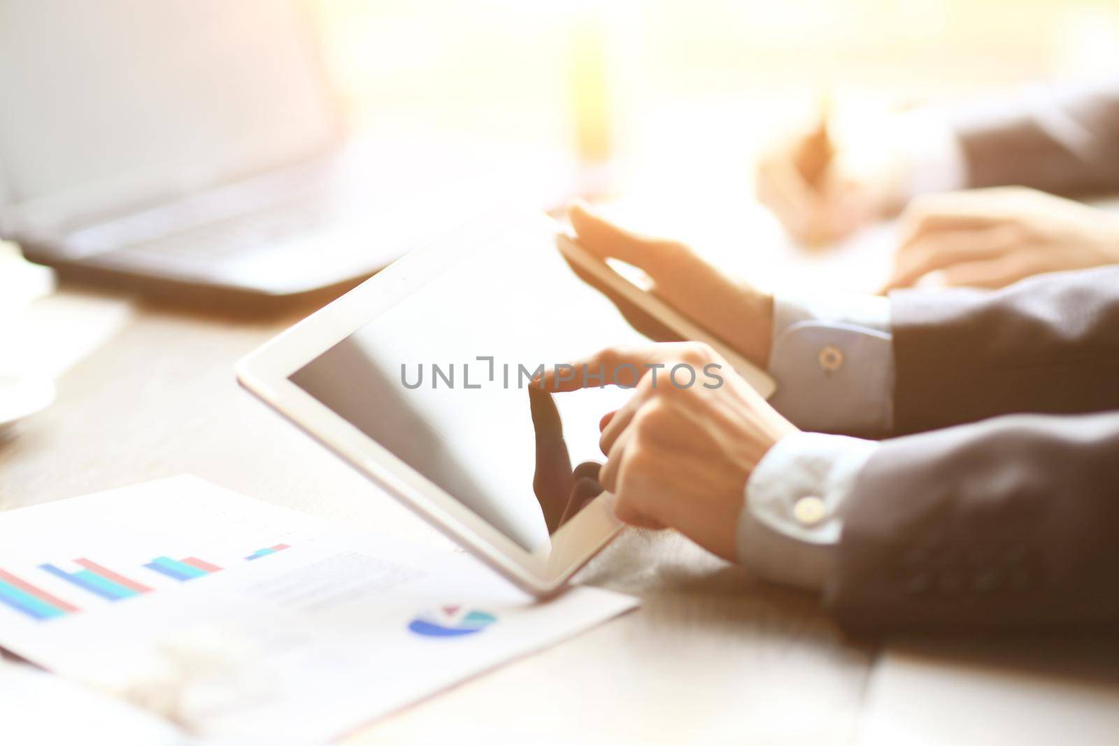 work of two young businessmen using touchpad at meeting
