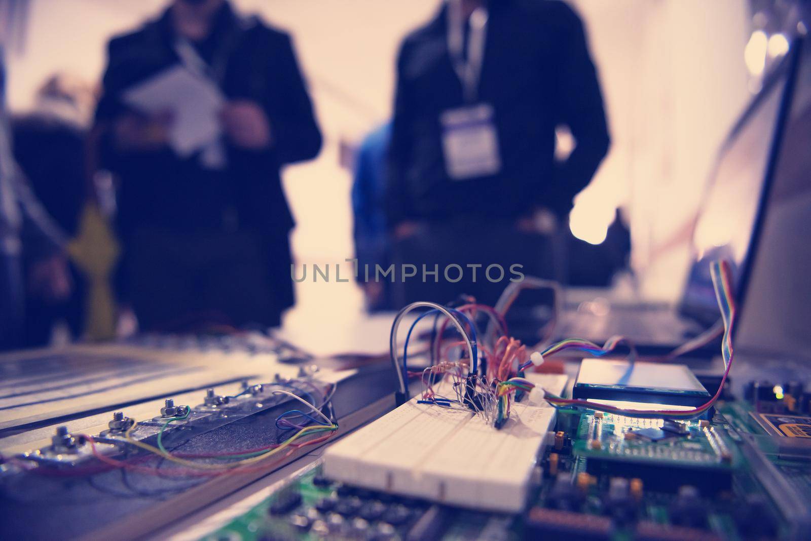 high technology electric circuit motherboard with team of computer engineers in background