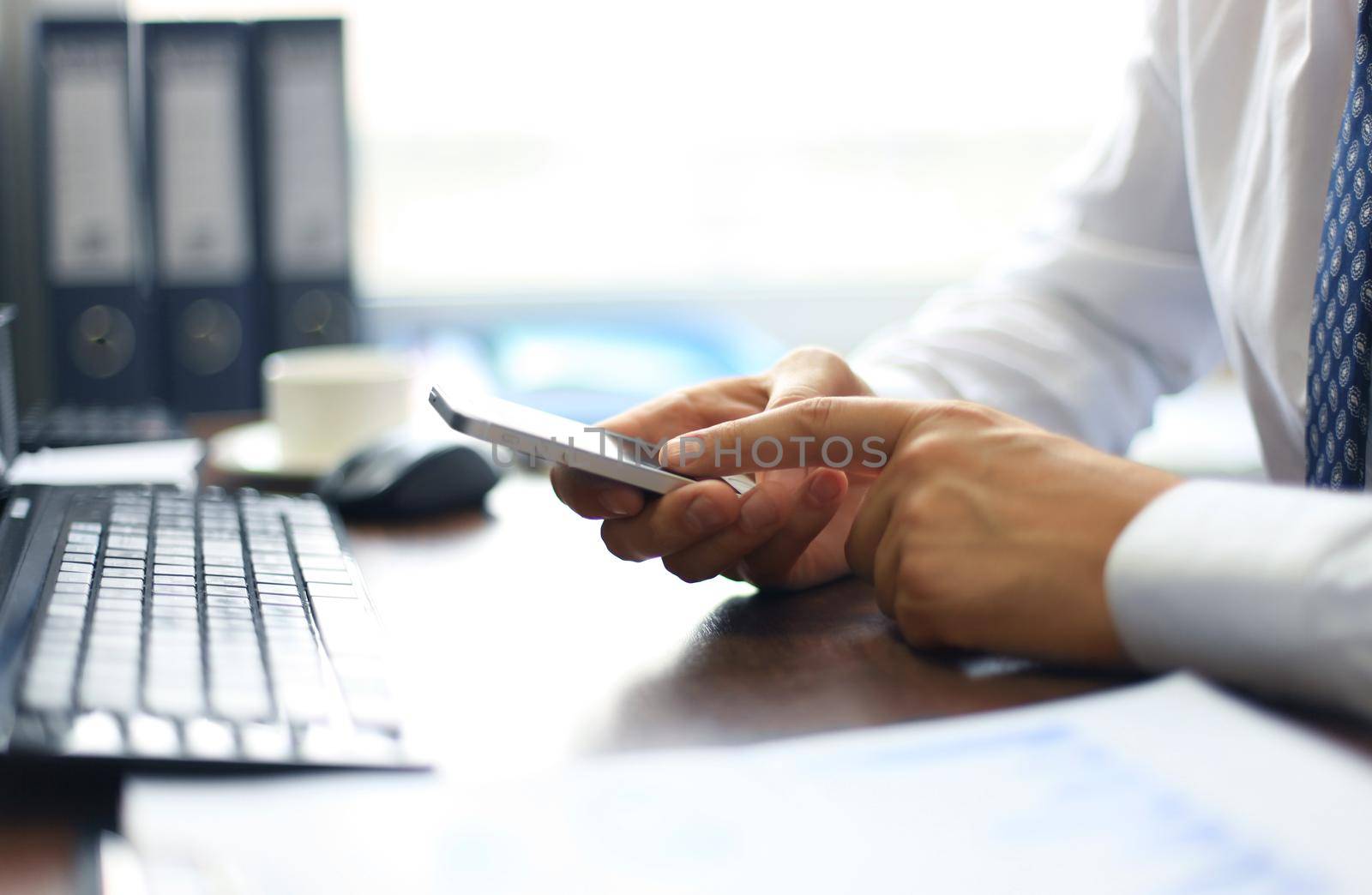 Close up of a business man using mobile smart phone