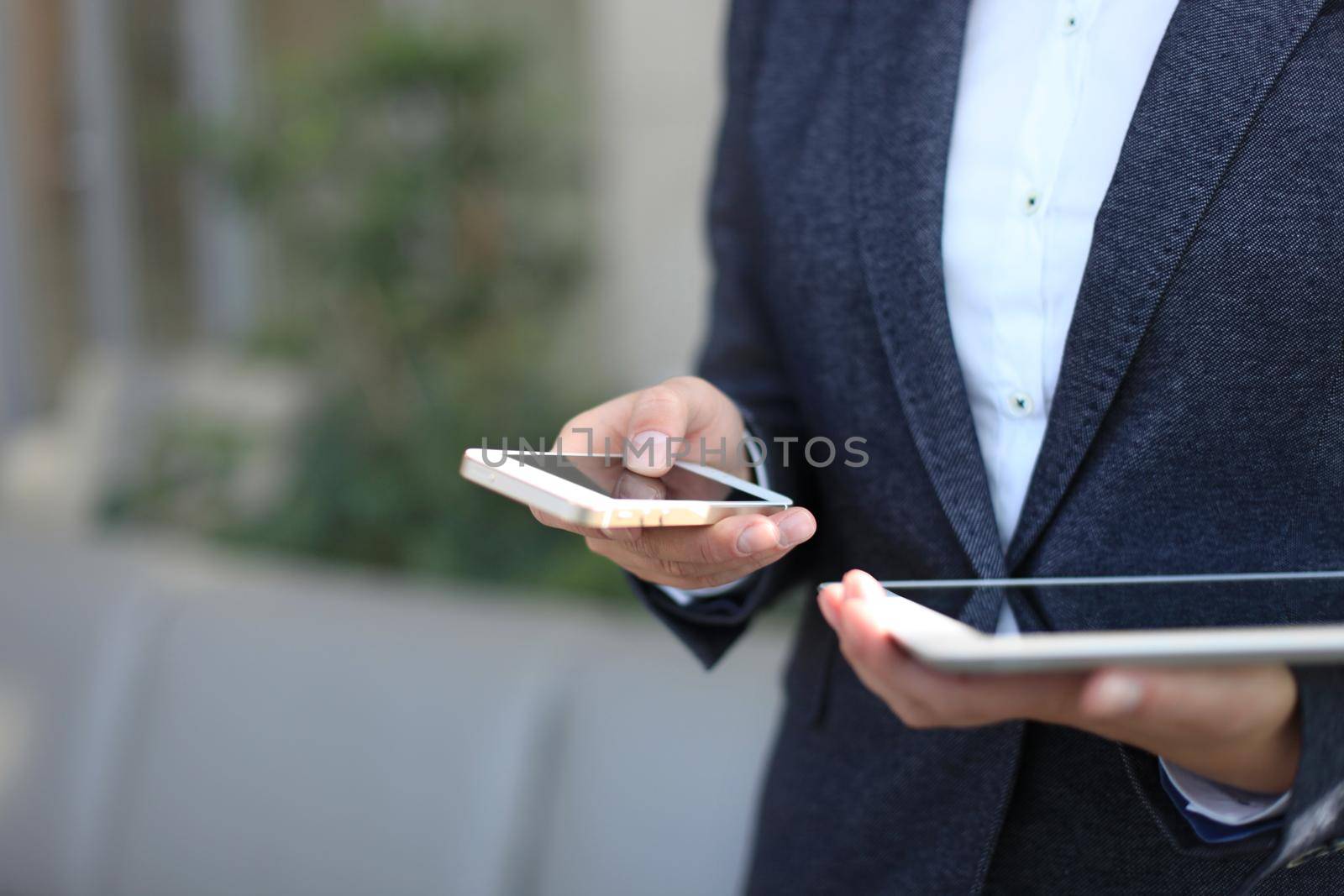 Young businesswoman working with modern devices, digital tablet computer and mobile phone by tsyhun