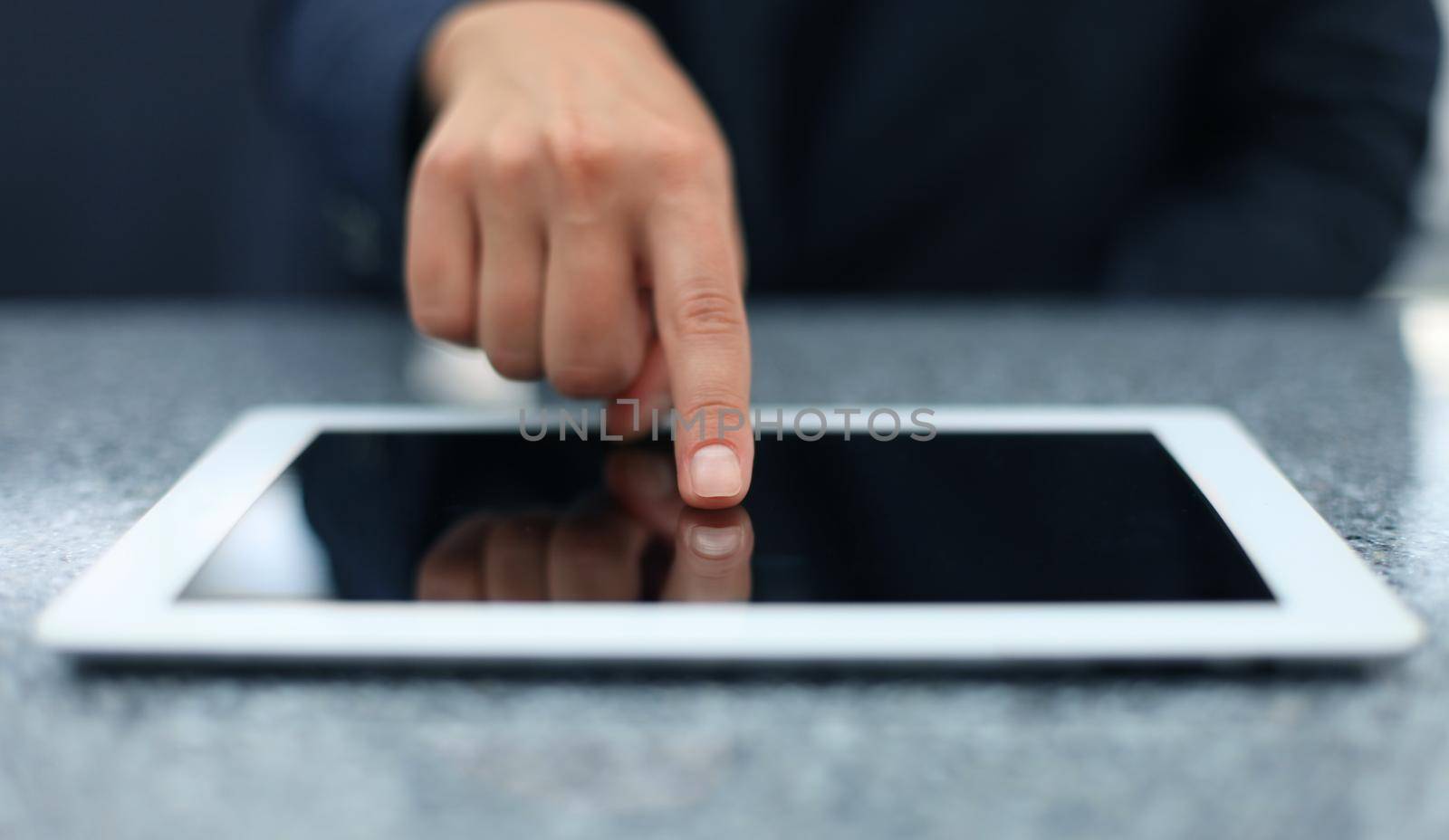 Woman hand touching screen on modern digital tablet pc. Close-up image with shallow depth of field focus on finger.