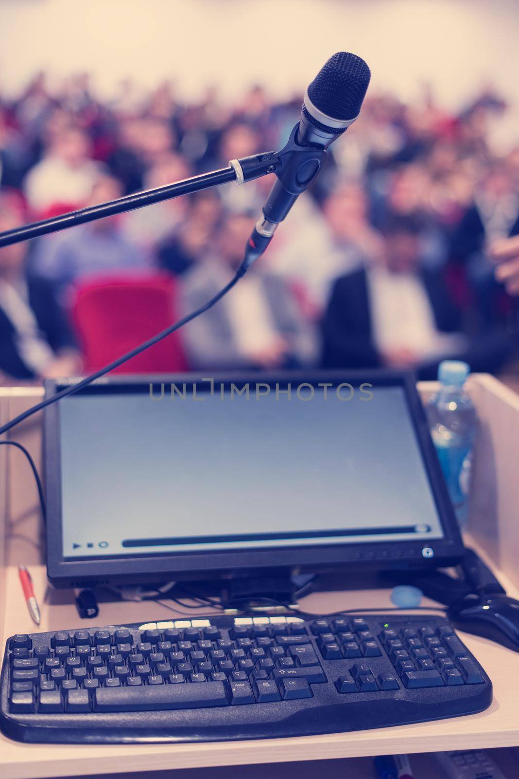 laptop computer and microphone at podium on business seminar education  in modern conference room