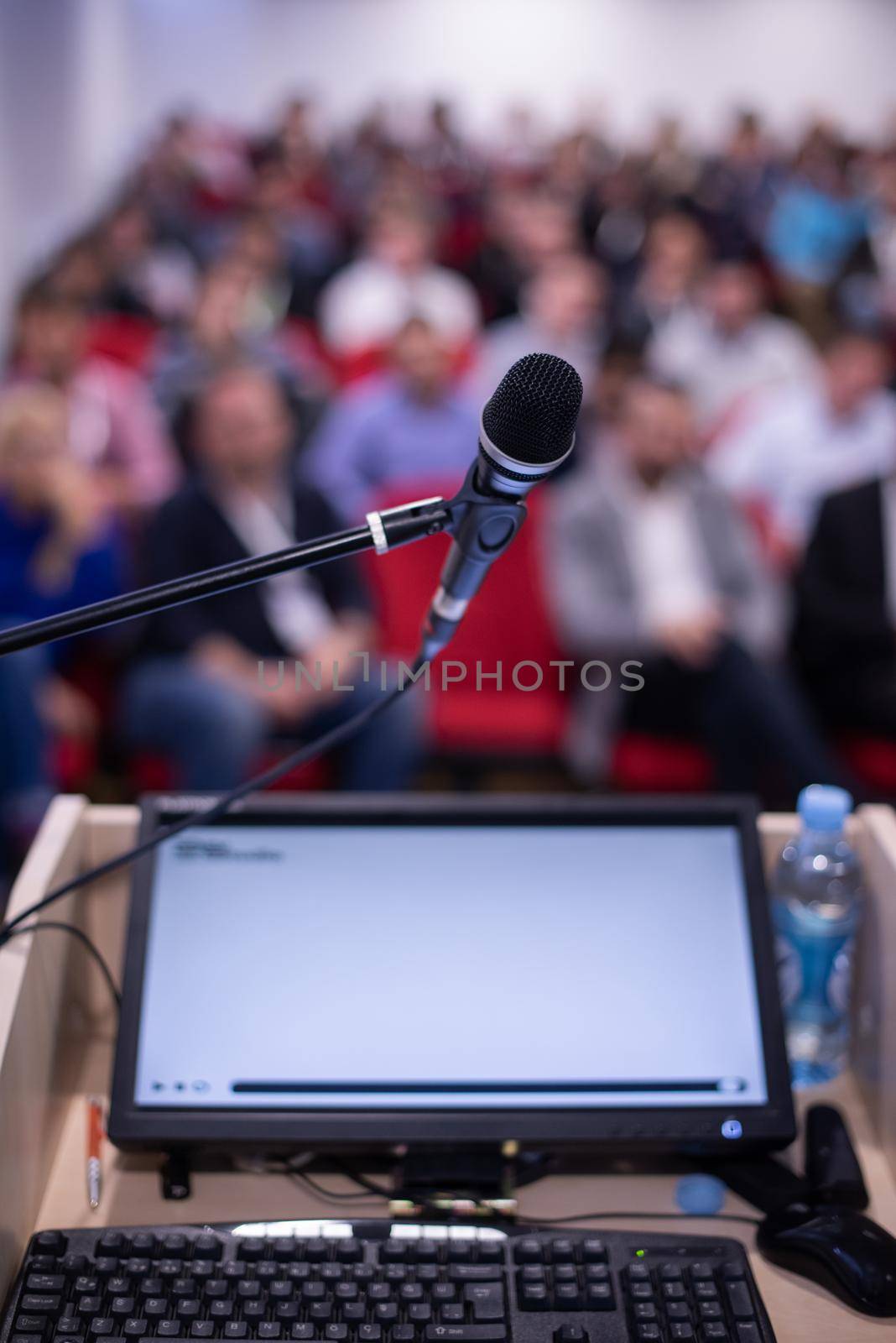 laptop computer and microphone at podium on business seminar education  in modern conference room