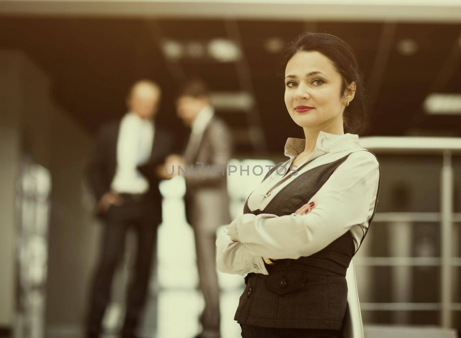 Portrait of a cute young business woman smiling, in an office environment