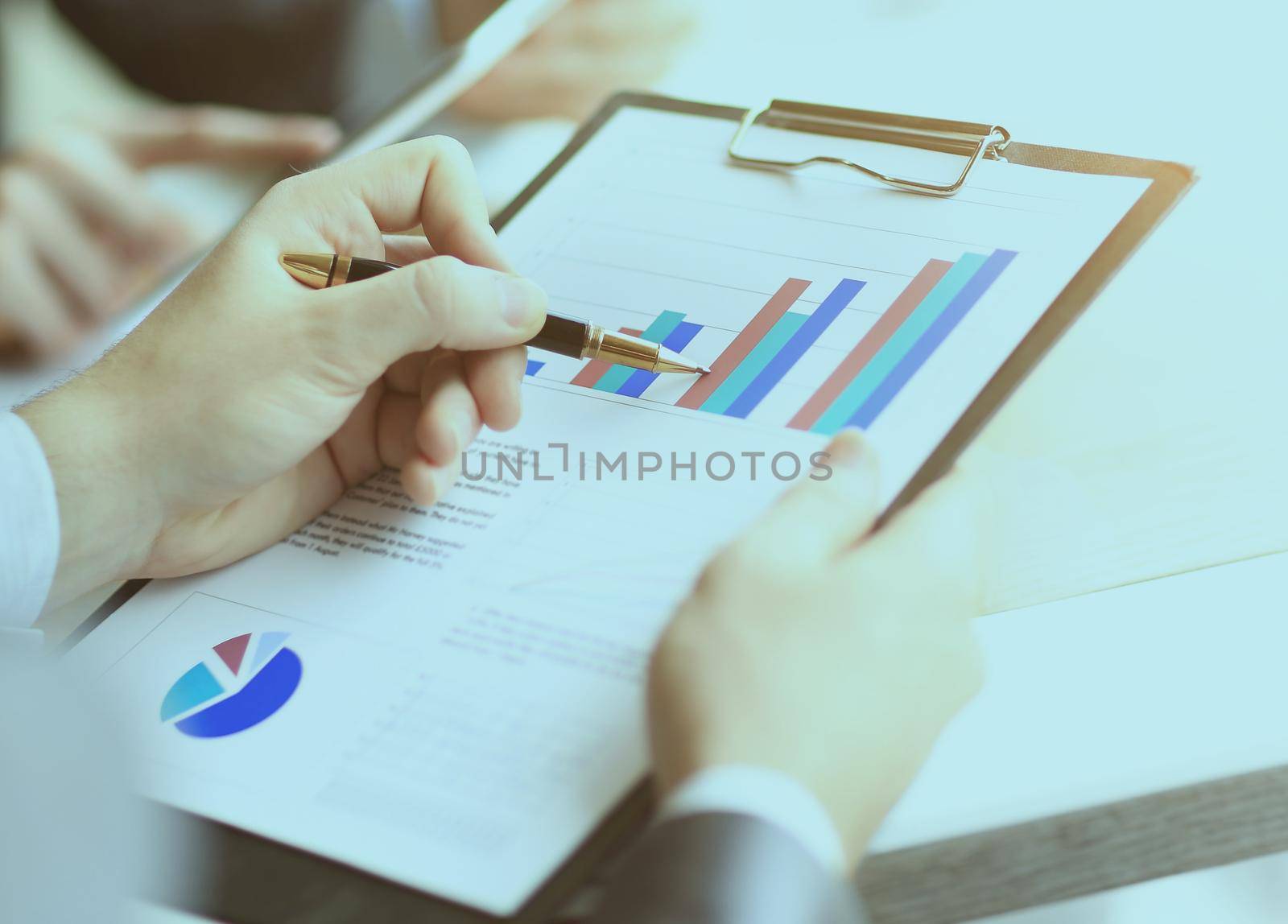 Image of male hand pointing at business document during discussion at meeting