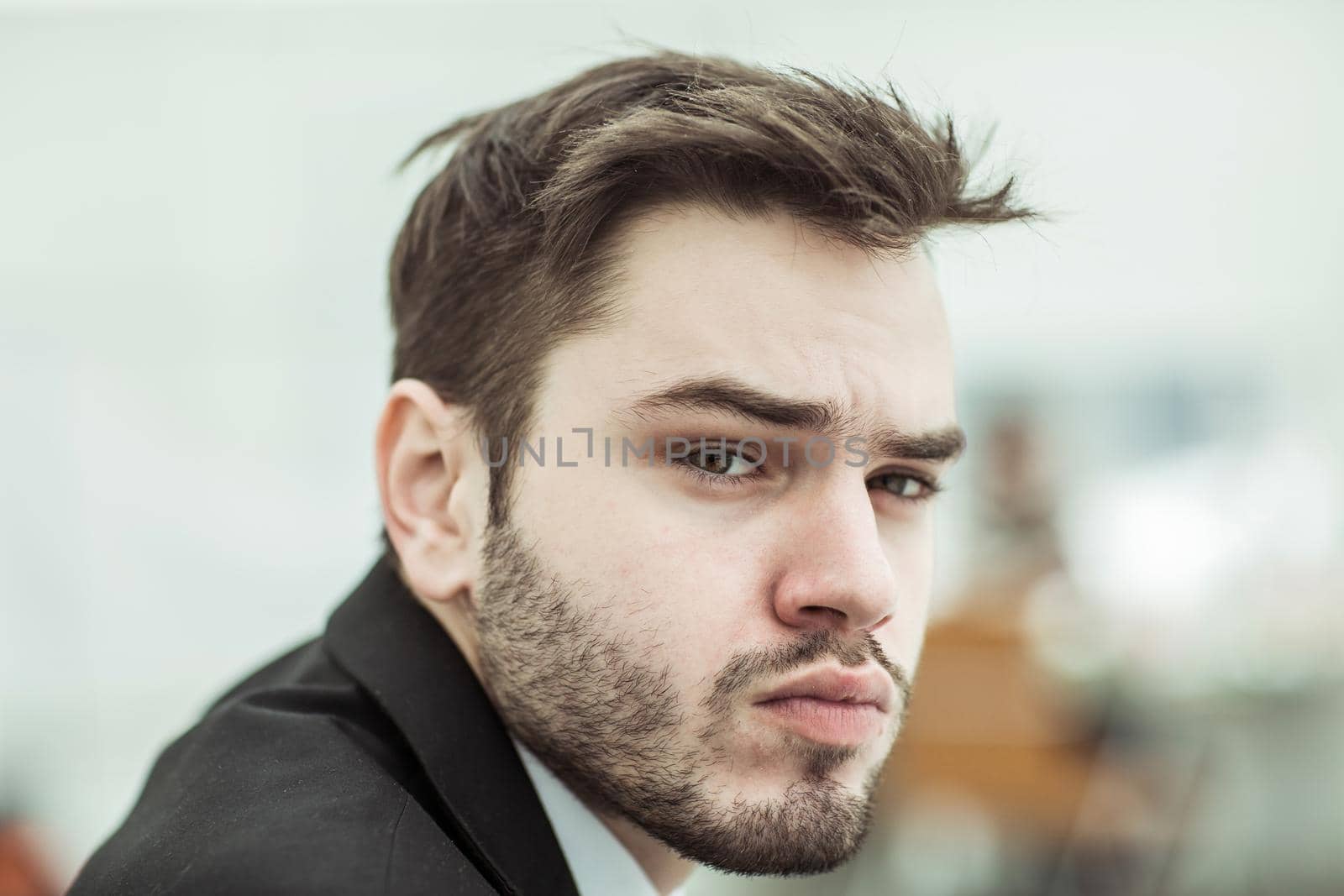 closeup - the face of serious businessman on background of office