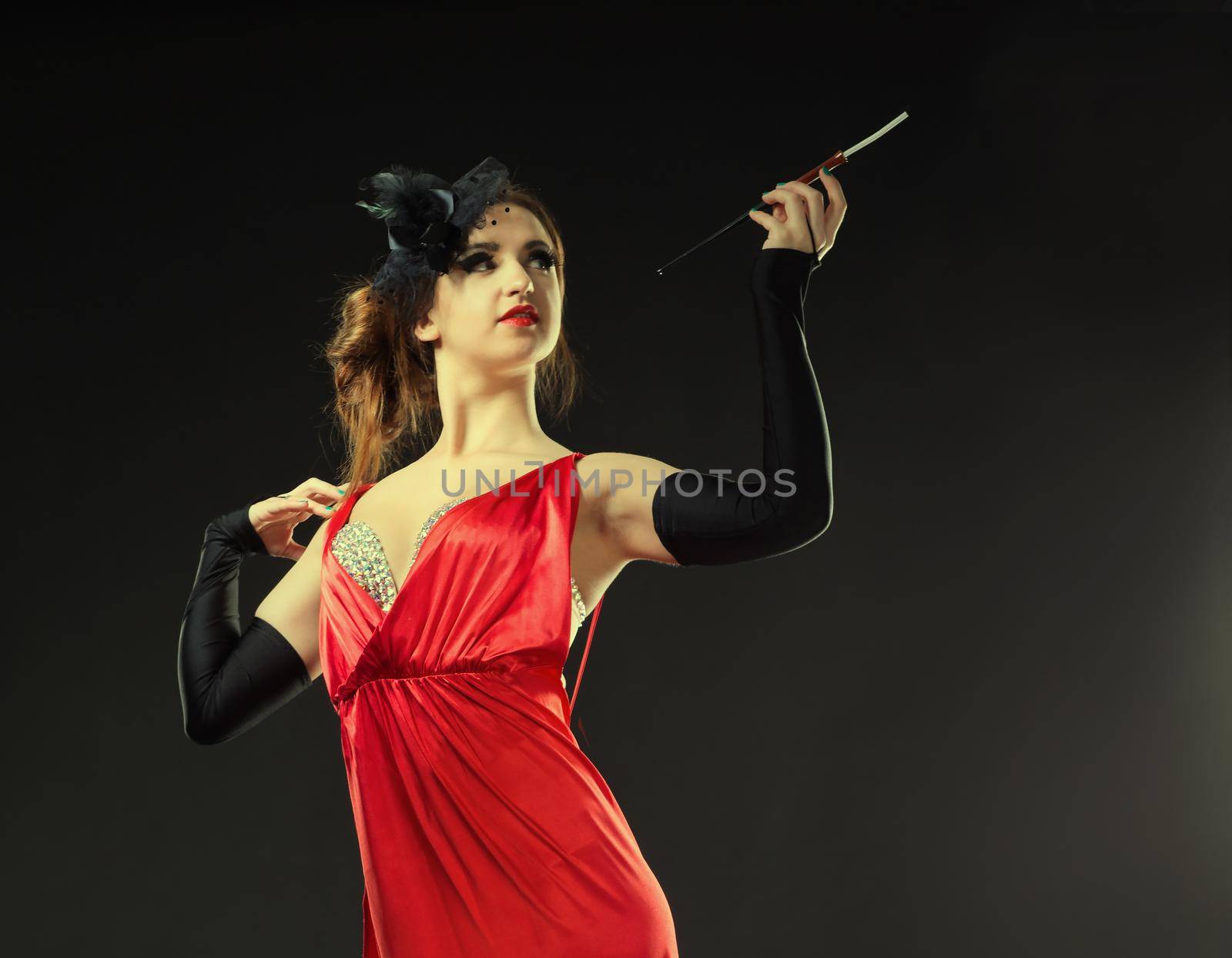 Beautiful young girl in a red dress with a cigarette, in the cabaret