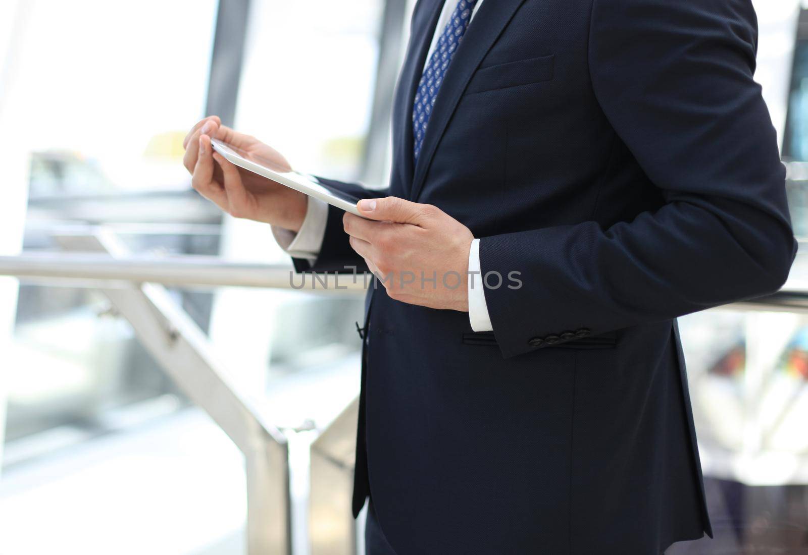 Midsection of businessman using digital tablet in office