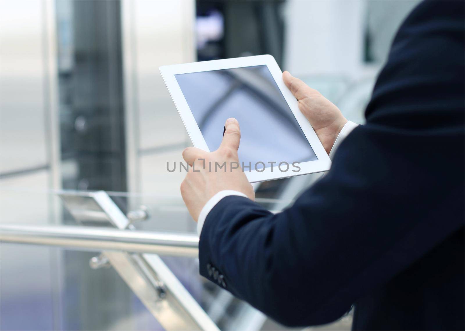 Midsection of businessman using digital tablet in office