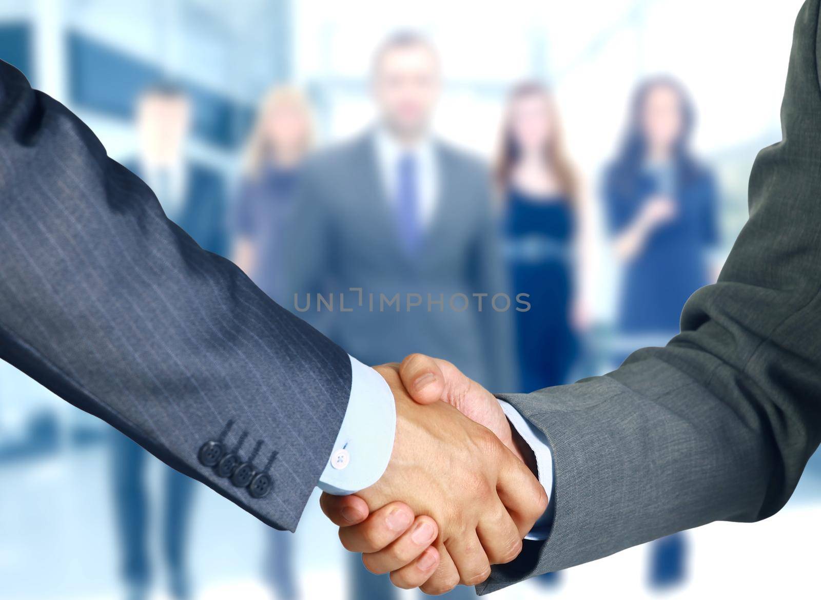 Business associates shaking hands in office