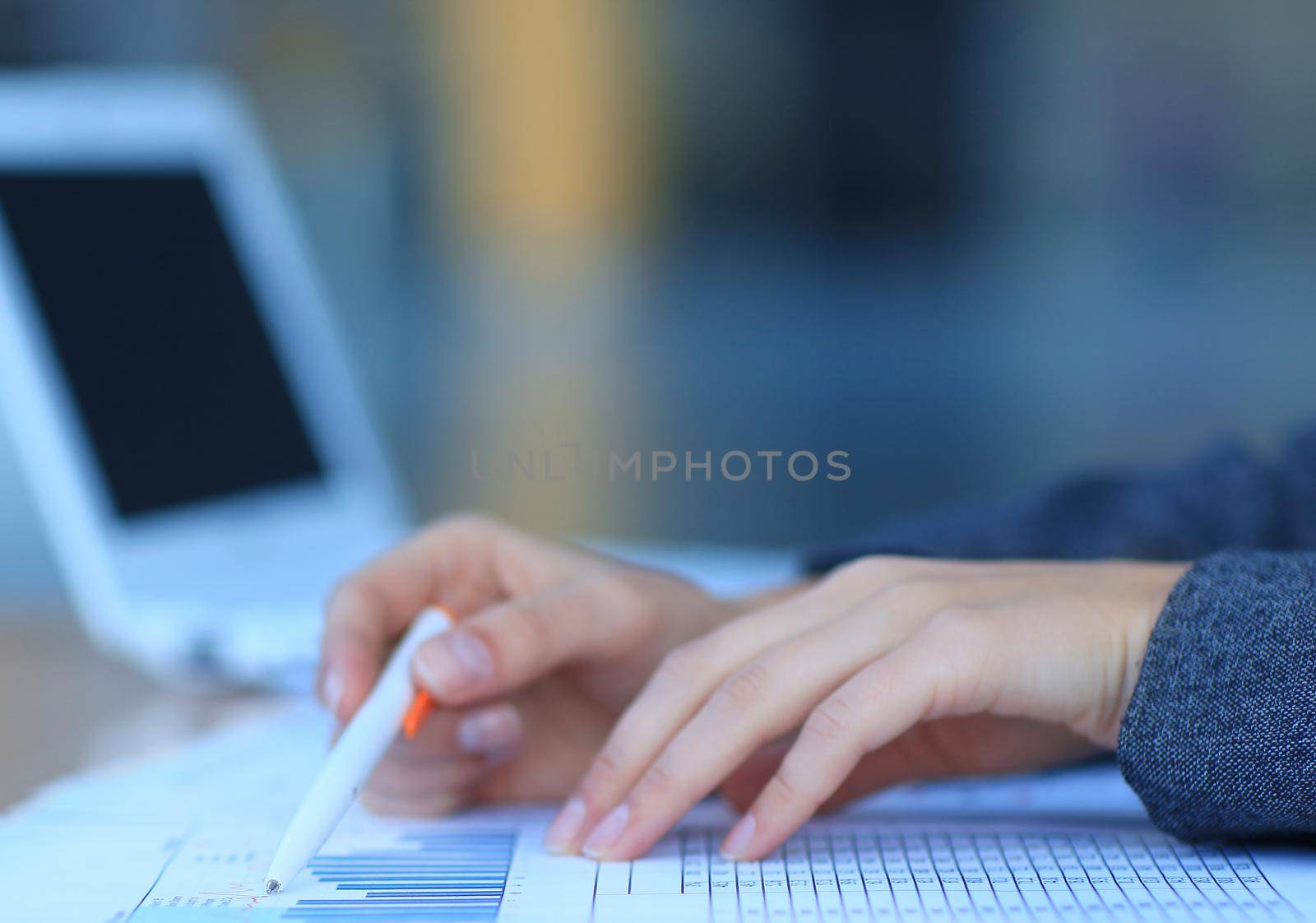 Close-up of female hand holding pen over business document