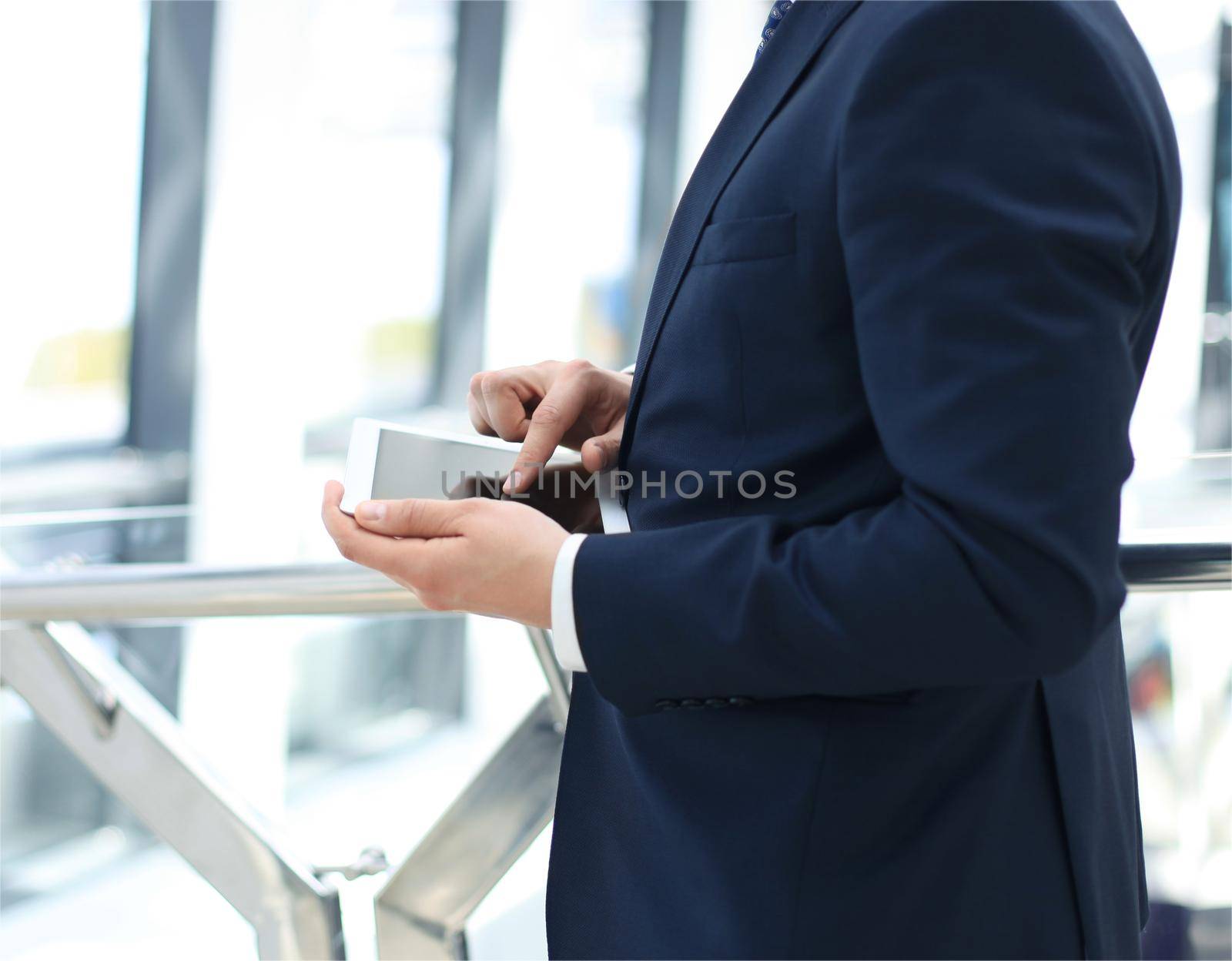 Midsection of businessman using digital tablet in office by tsyhun