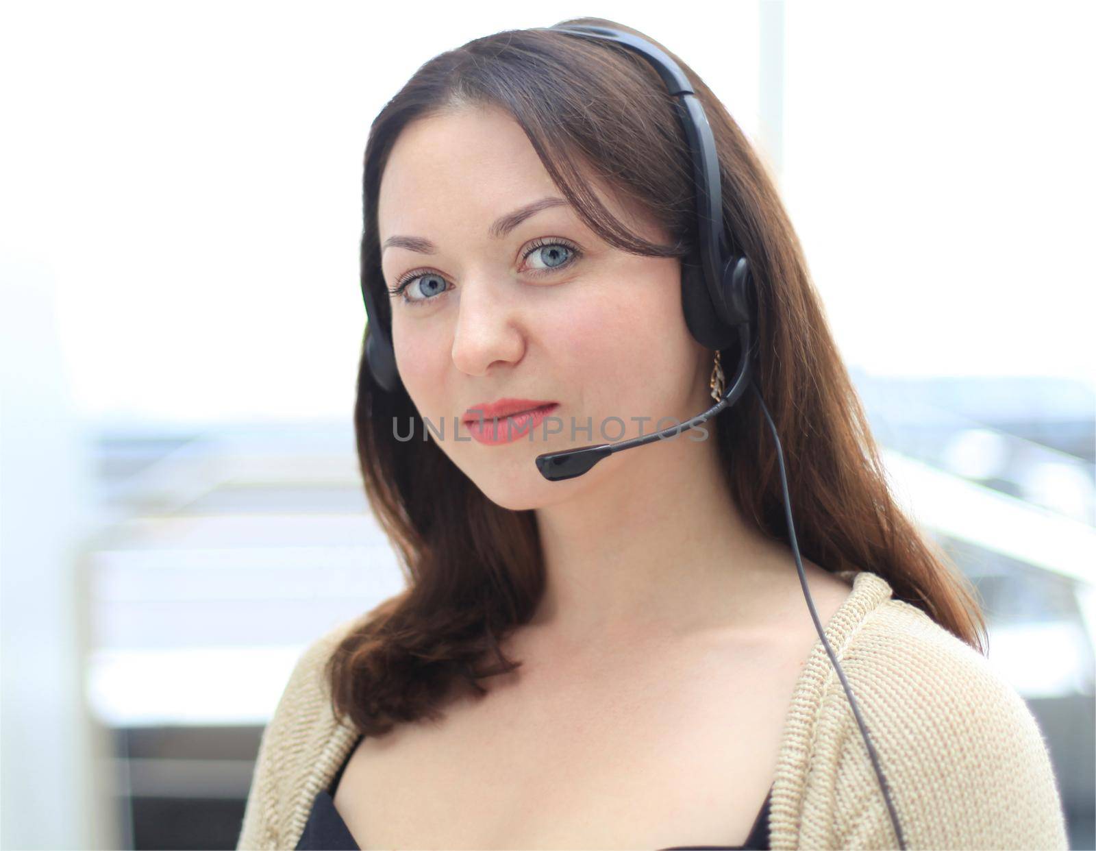 Beautiful young female call center operator with headset in office by tsyhun