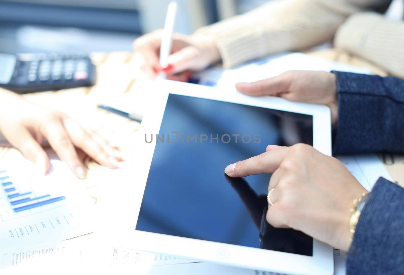 Business person analyzing financial statistics displayed on the tablet screen