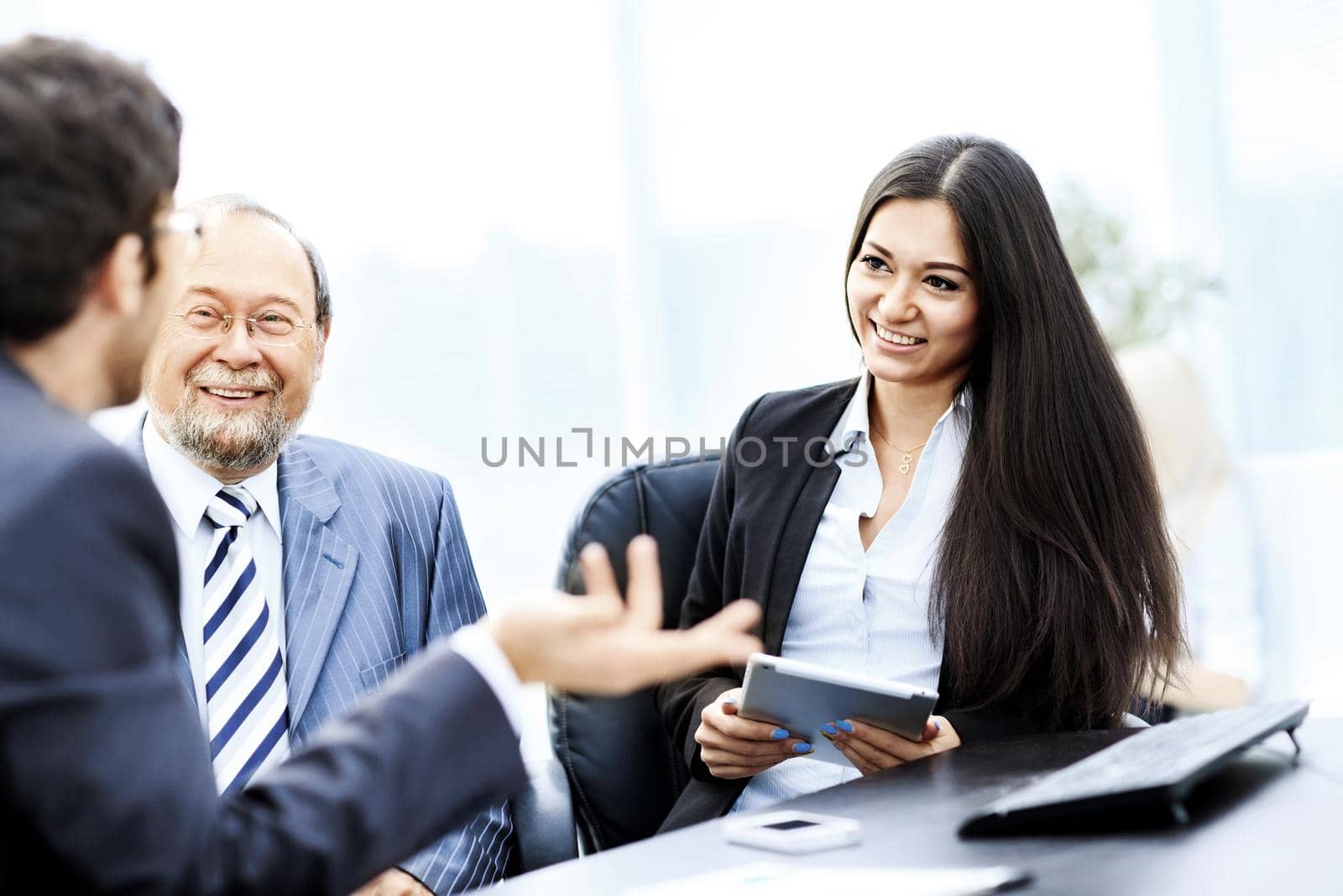 Image of business partners discussing documents and ideas at meeting in office