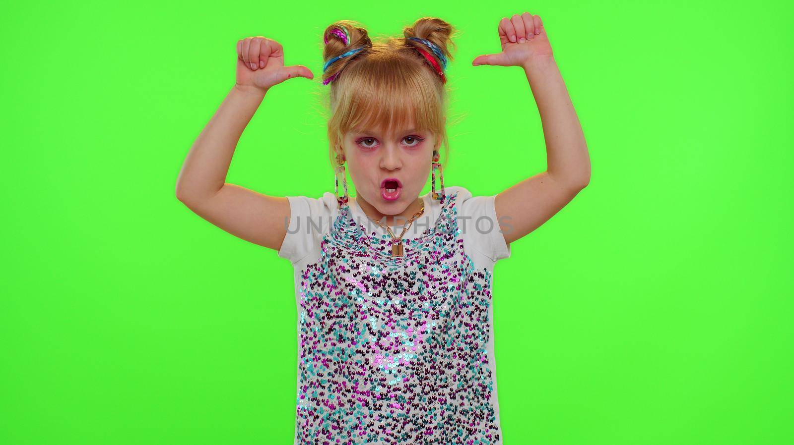 Stylish kid girl making trendy dance video for social media network, child dancing, blogger fun activity challenge, children hobbies games after school. Schoolgirl child on green chroma key background