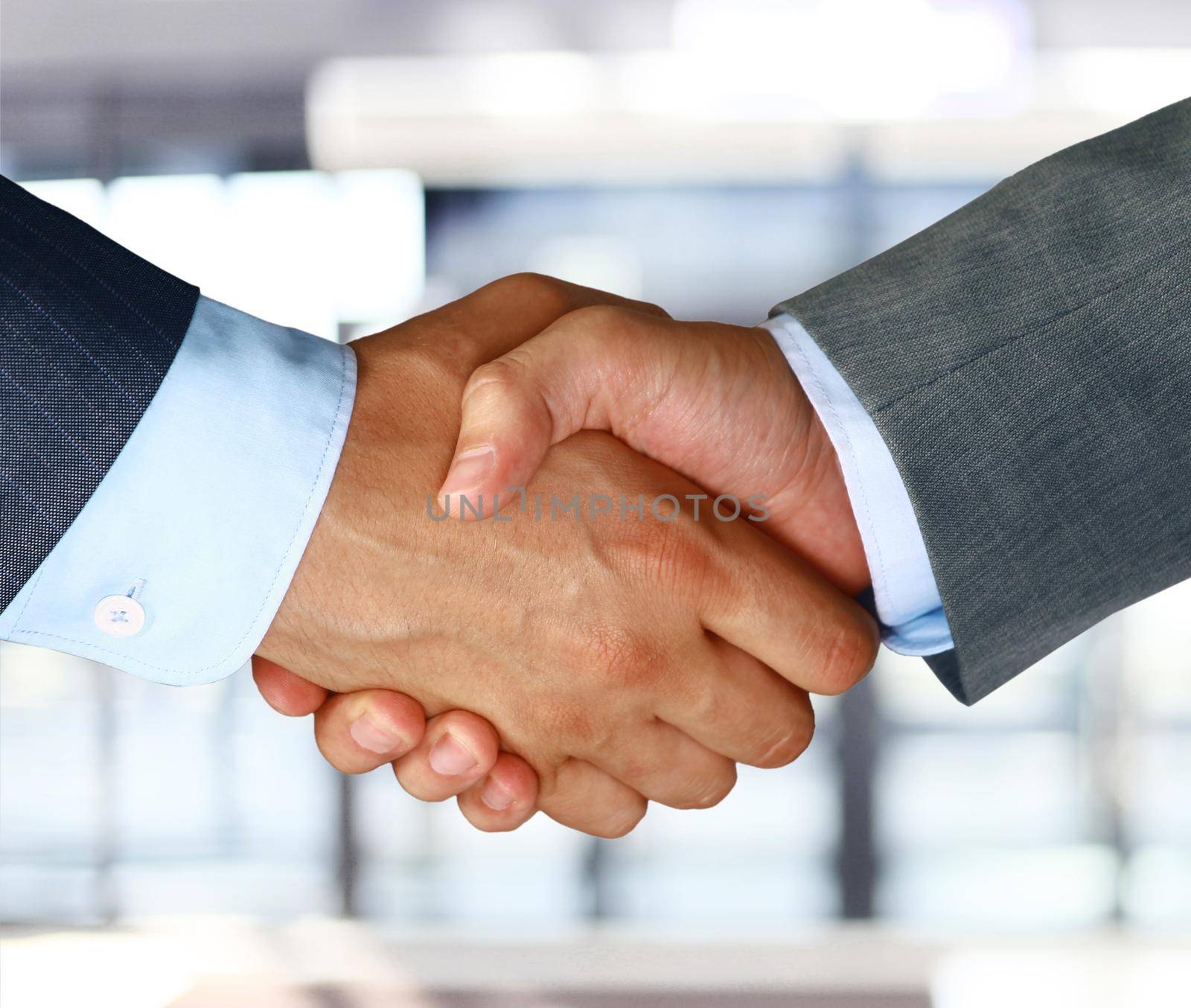 Closeup of a business hand shake between two colleagues by tsyhun