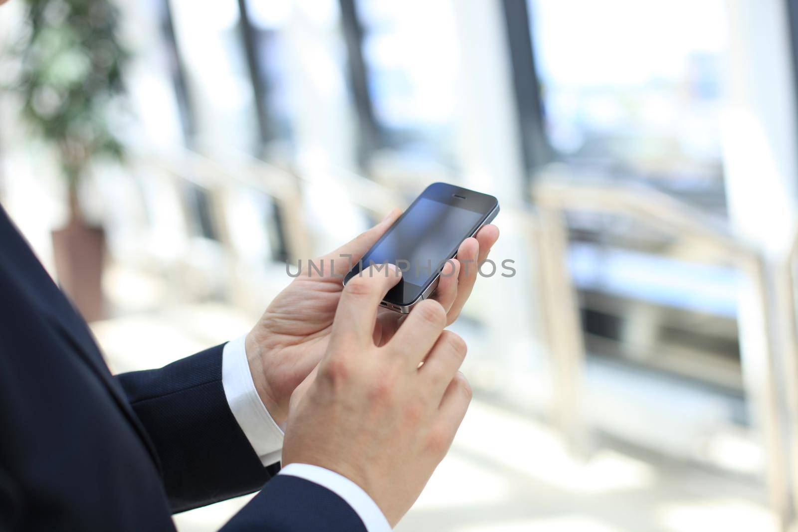 Close up of a business man using mobile smart phone by tsyhun