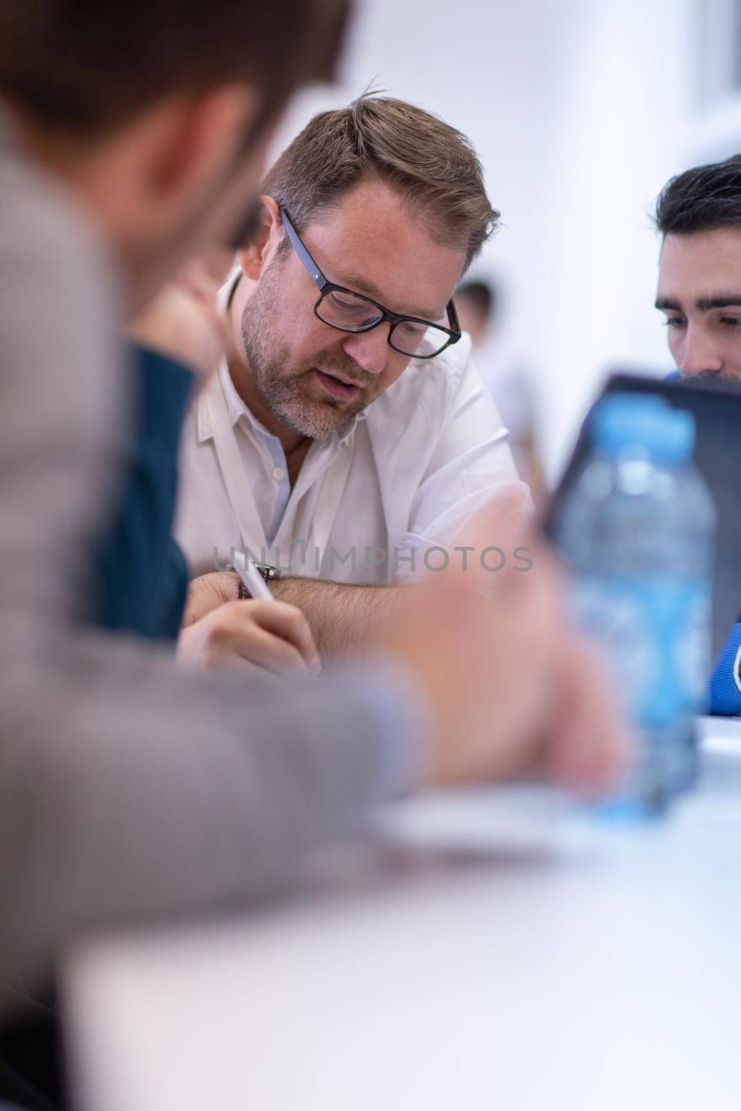 Group of a young business people brainstorming and discussing business plan on meeting at startup office interior