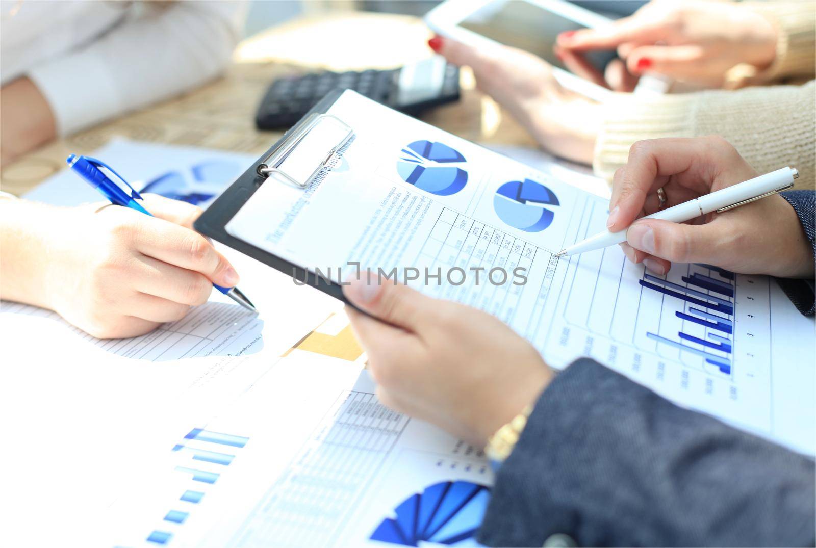 Unrecognizable business person analyzing graphs and taking notes by tsyhun