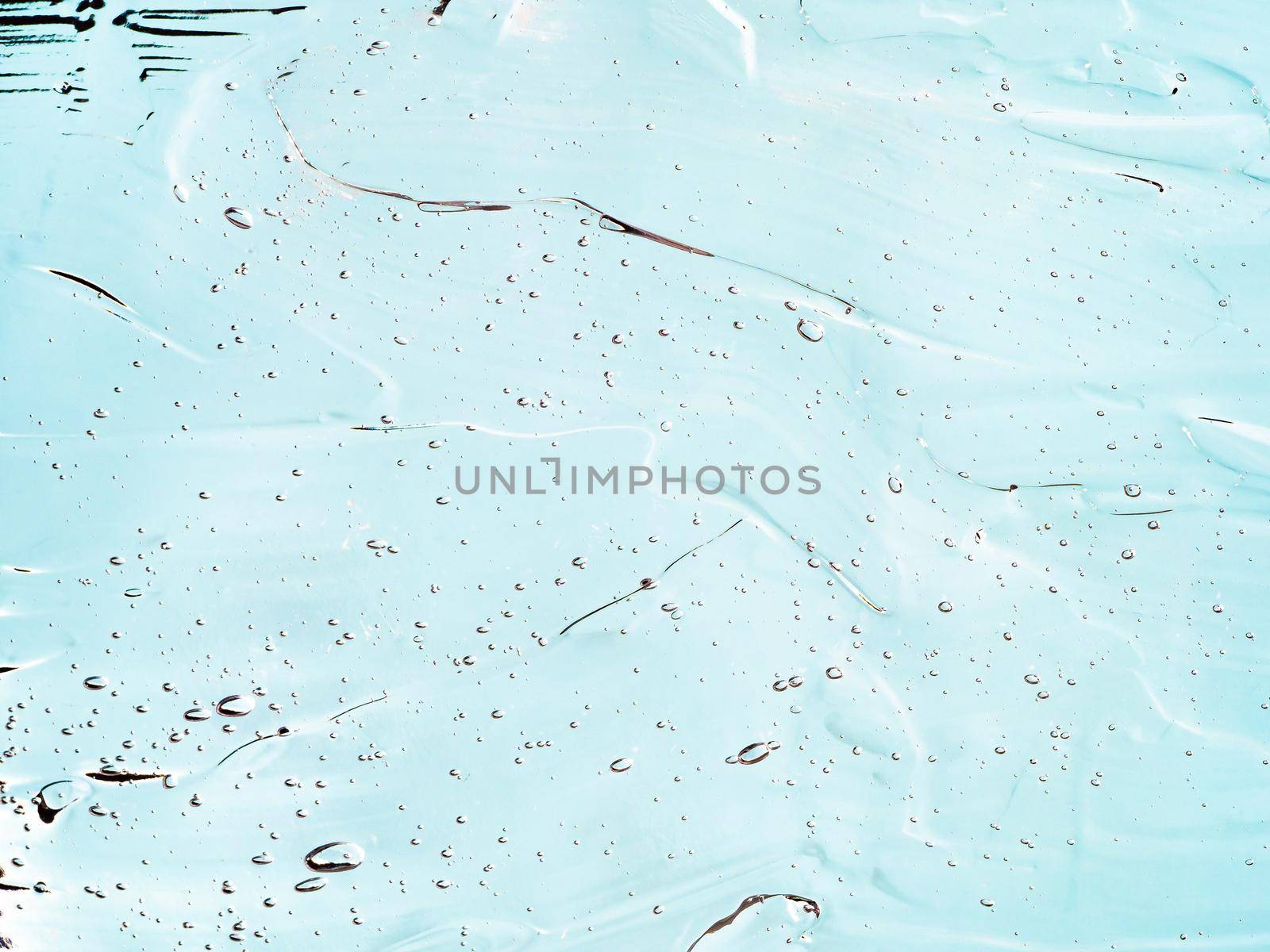 Liquid gel cosmetic texture on blue background. Aesthetic beautiful textured smears transparent skin gel. Top view or flat lay