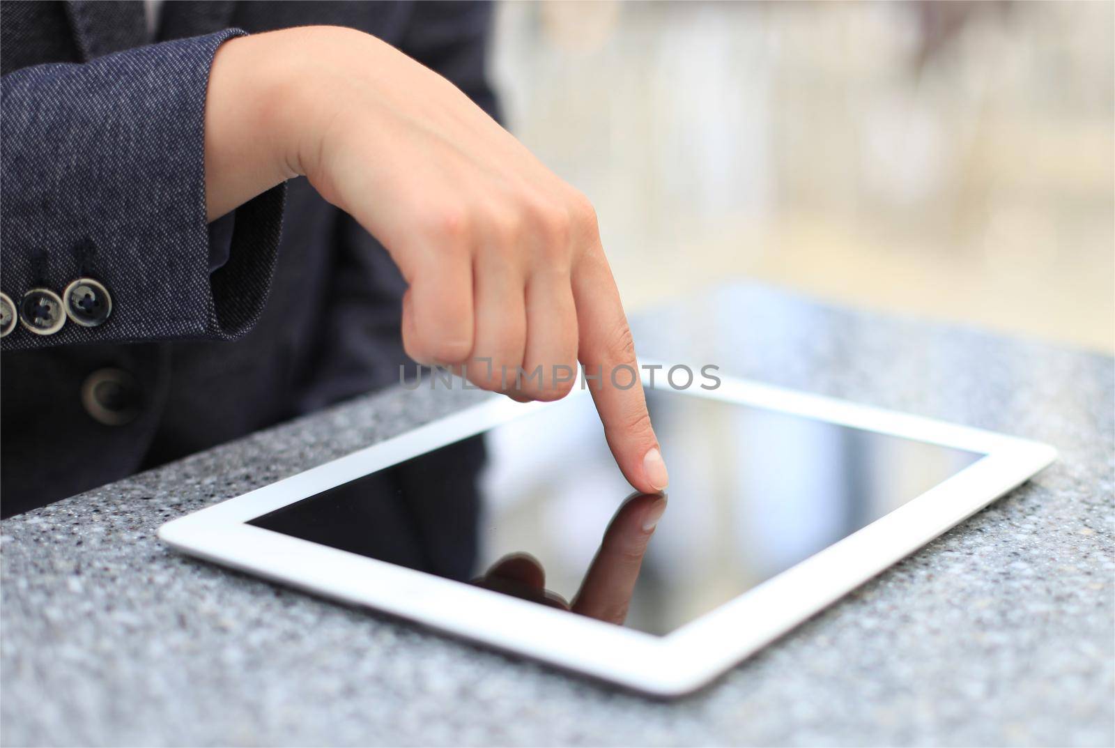 Woman hand touching screen on modern digital tablet pc. Close-up image with shallow depth of field focus on finger. by tsyhun
