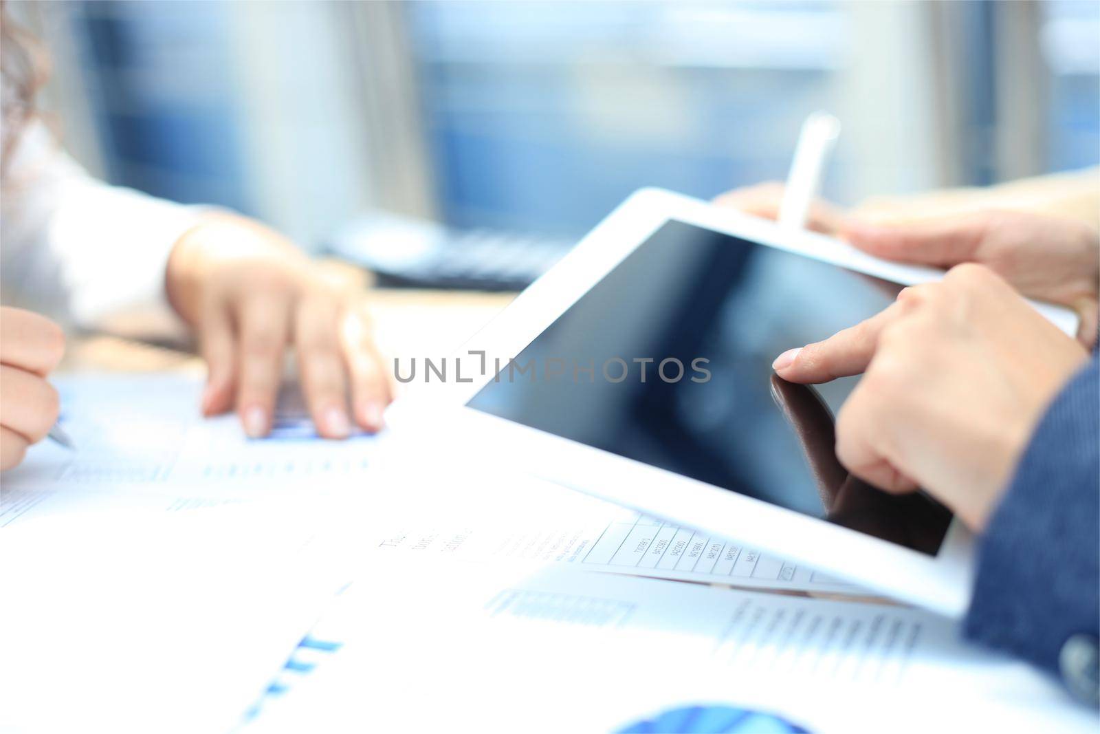 Business person analyzing financial statistics displayed on the tablet screen