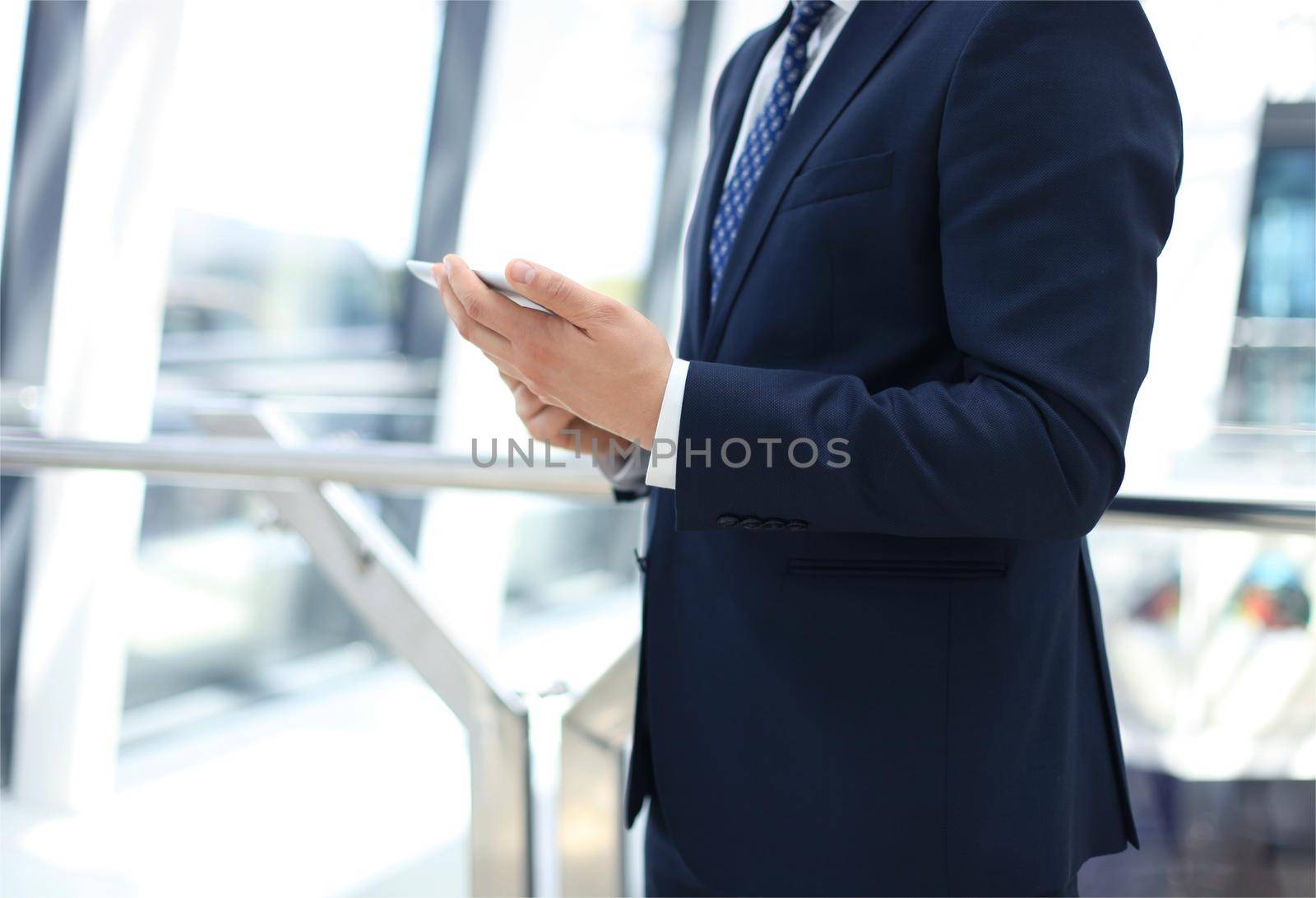 Midsection of businessman using digital tablet in office by tsyhun
