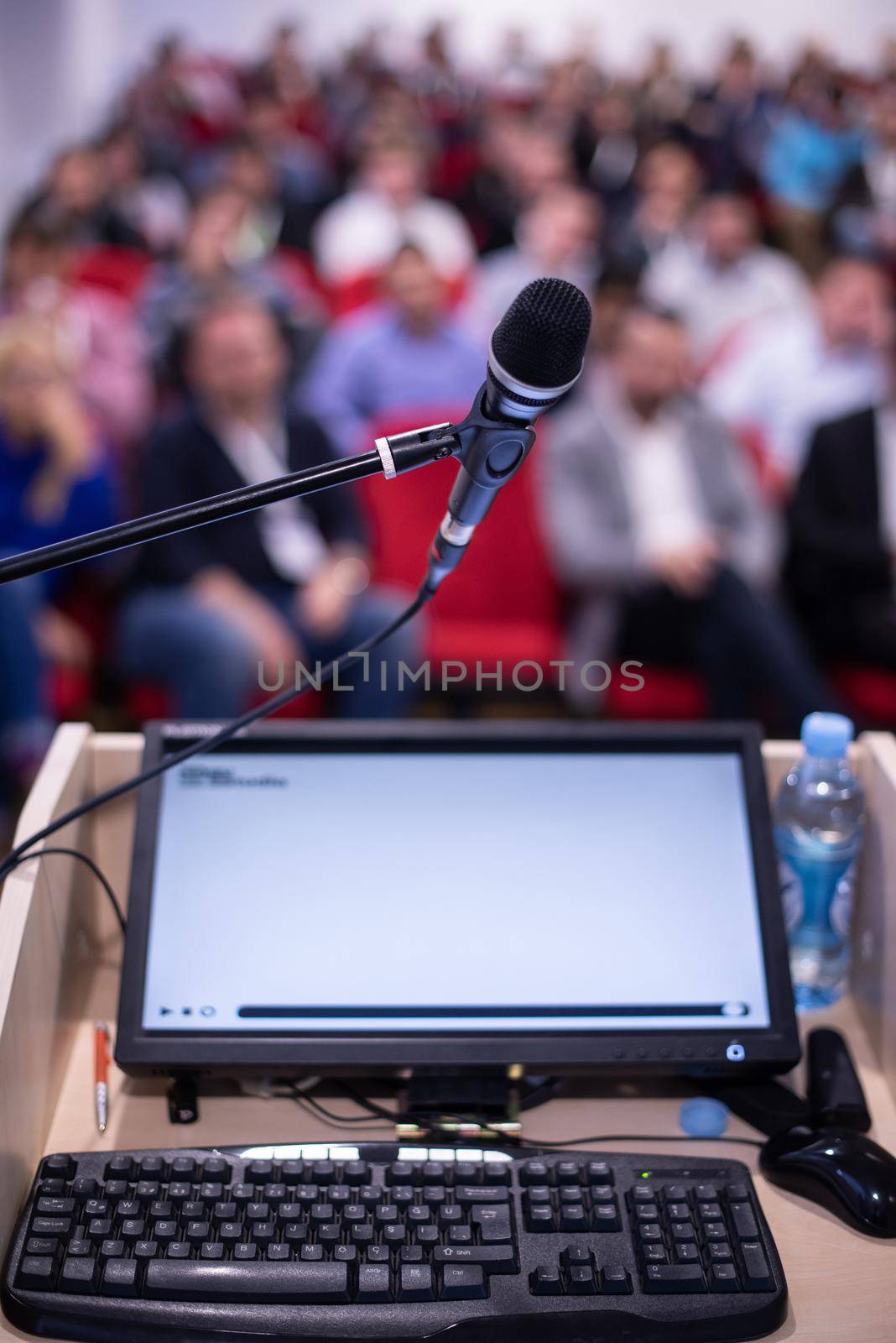 laptop computer and microphone at podium on business seminar education  in modern conference room