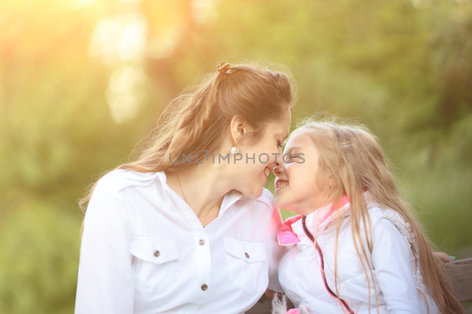 portrait of mother and daughter against the background of the Park on a Sunny day