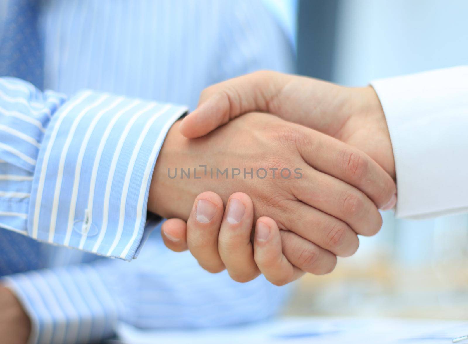 Closeup of a business hand shake between two colleagues by tsyhun