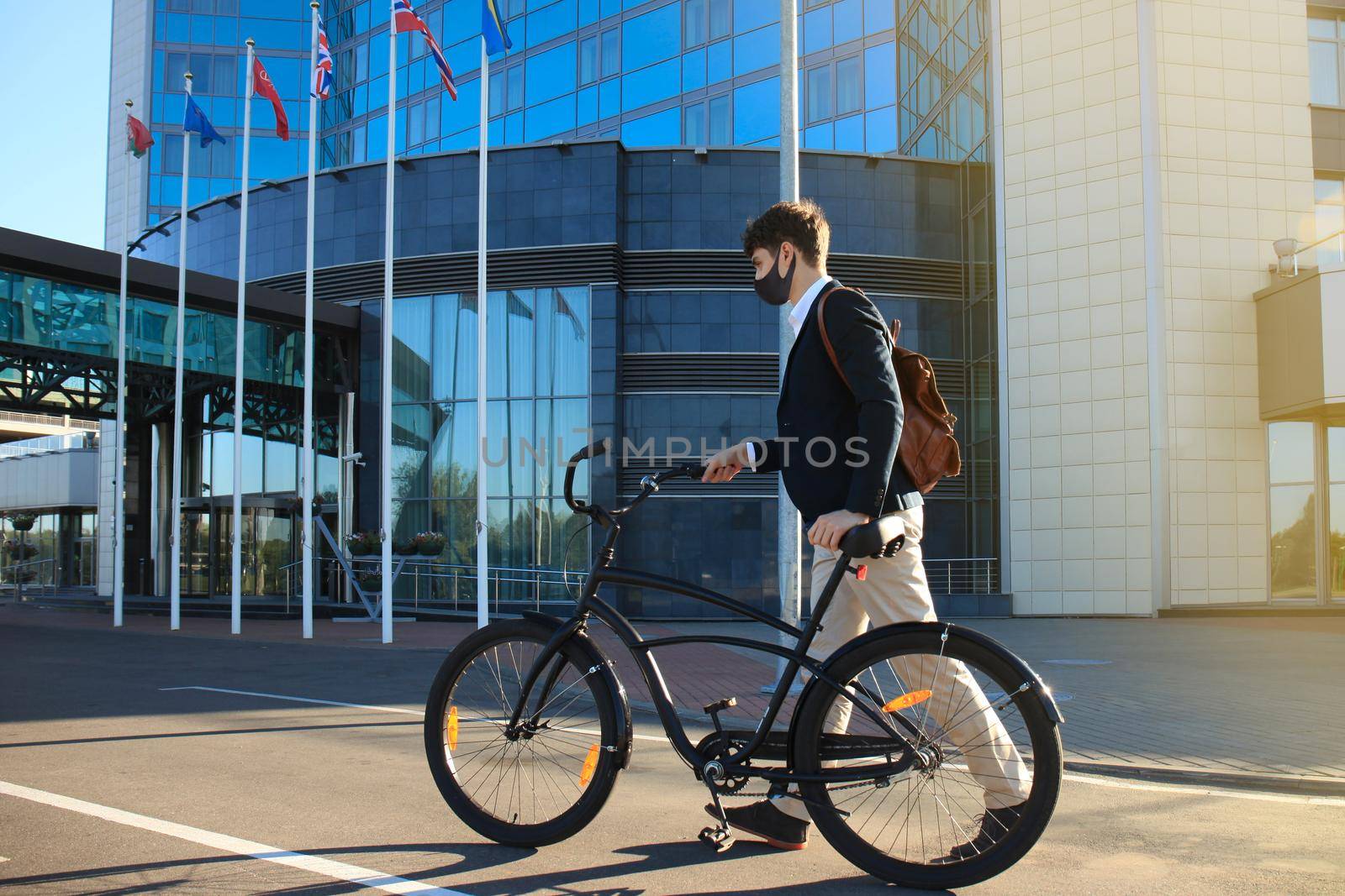 Handsome man in protective mask riding a bicycle to find job. by tsyhun