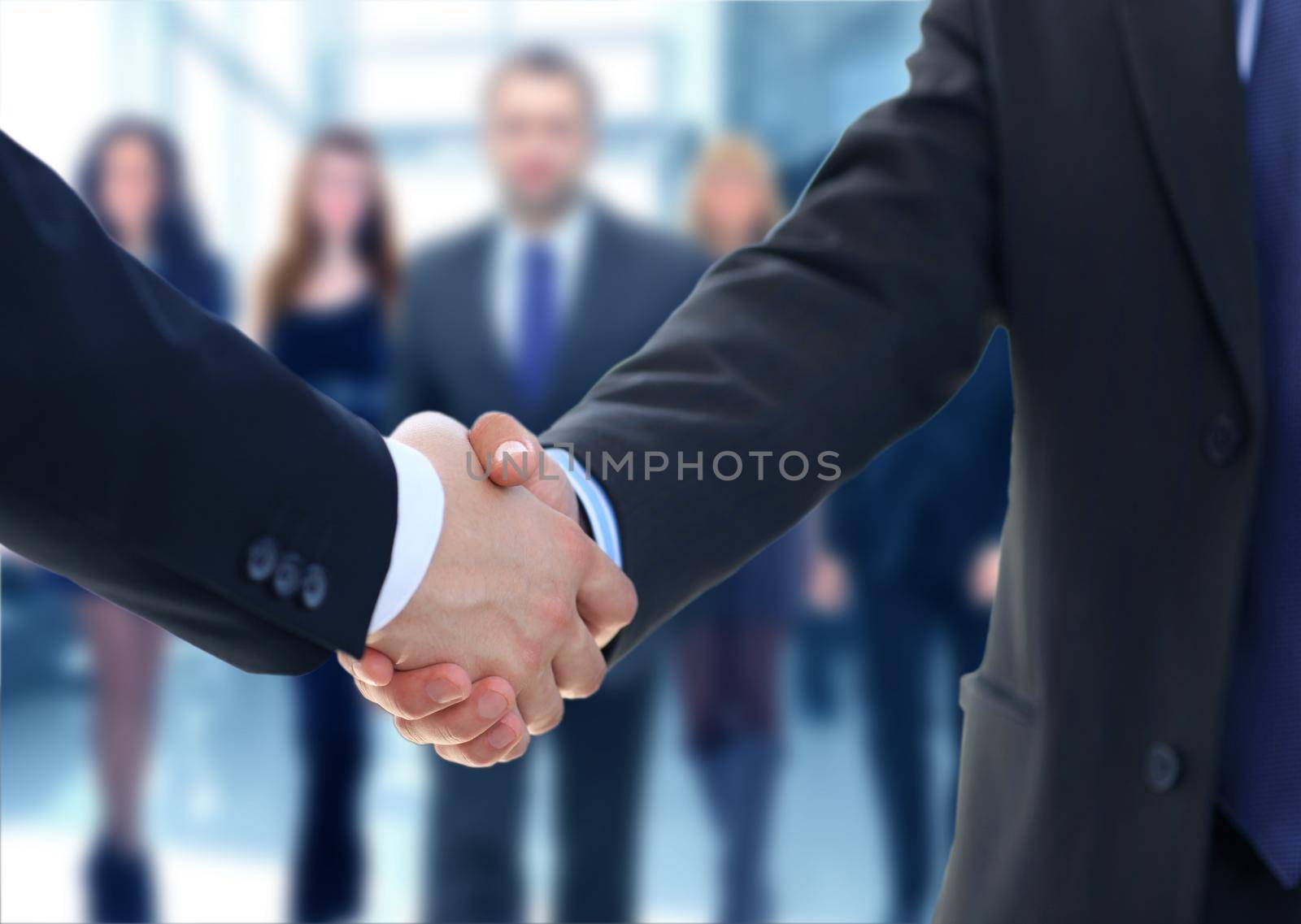 Business associates shaking hands in office by tsyhun