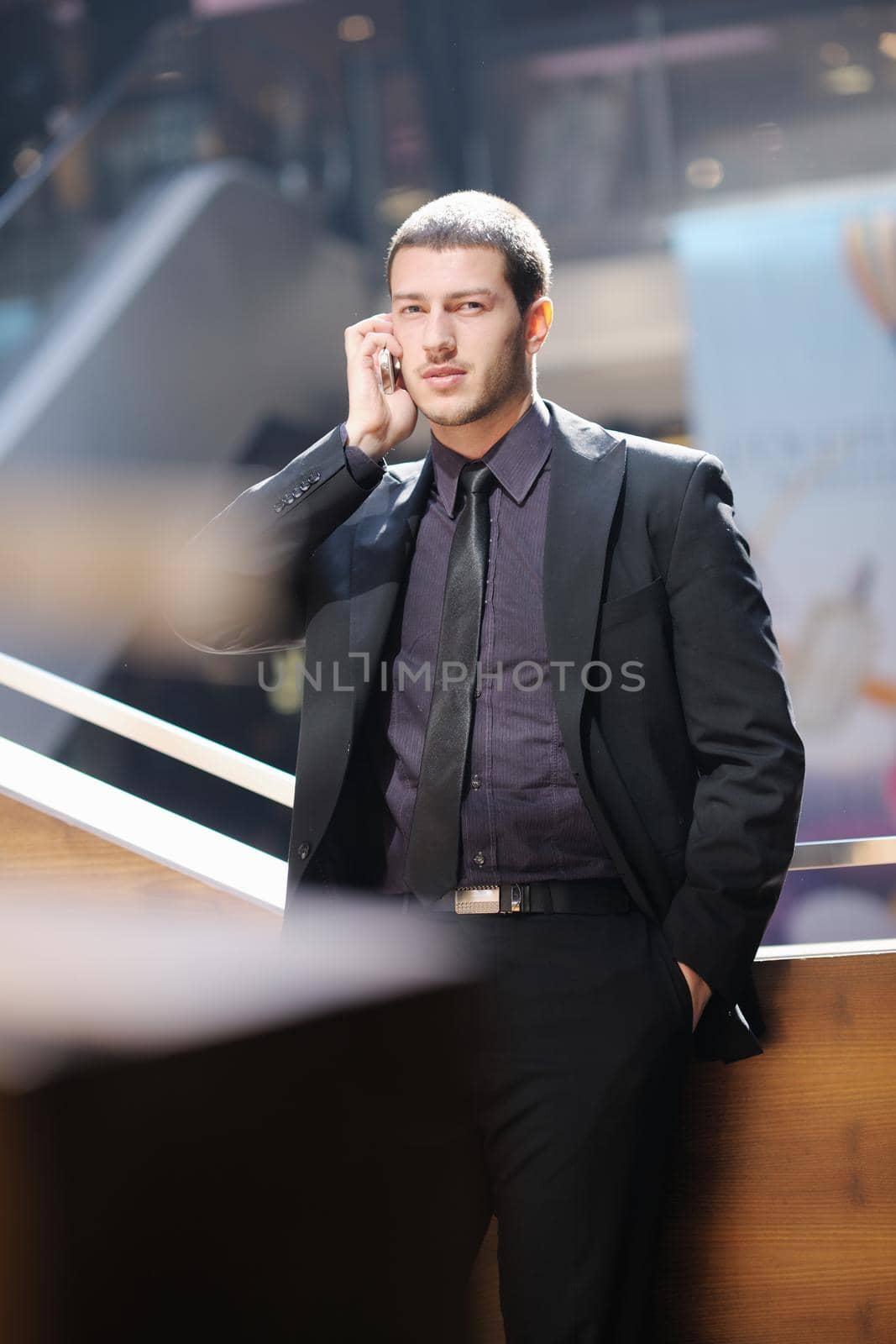 handsome young business man talking by cell phone outdoor