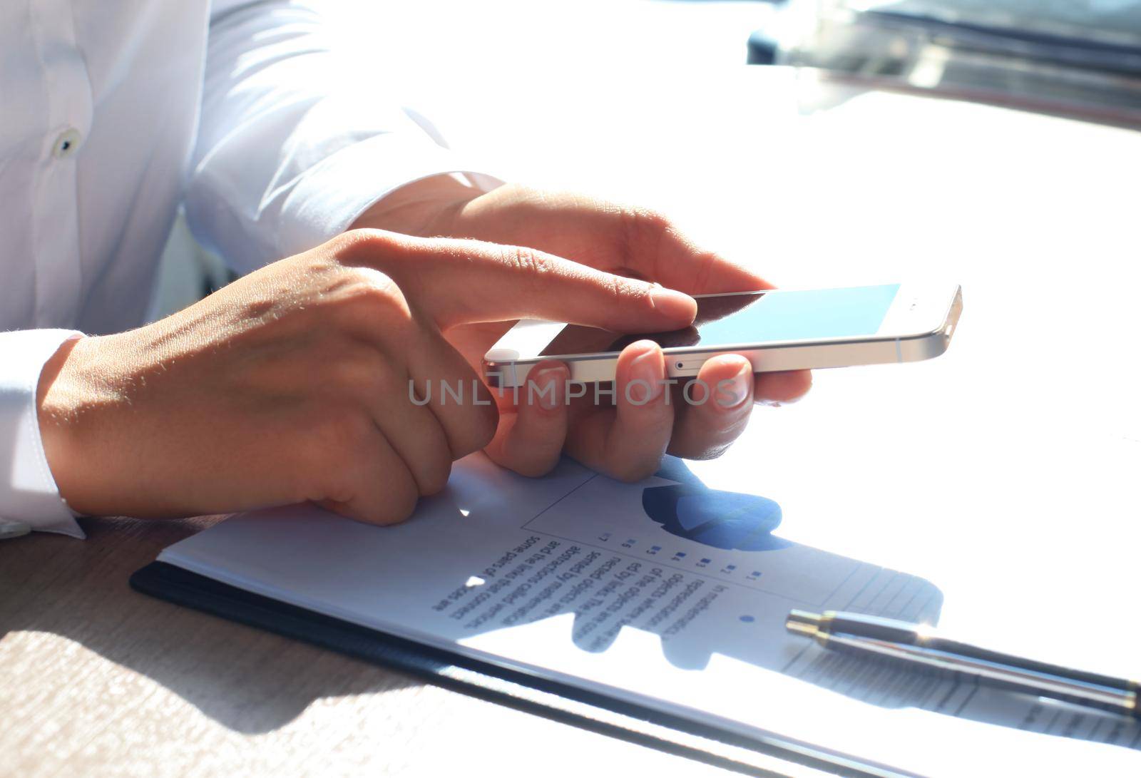Close up of a business woman using mobile smart phone by tsyhun